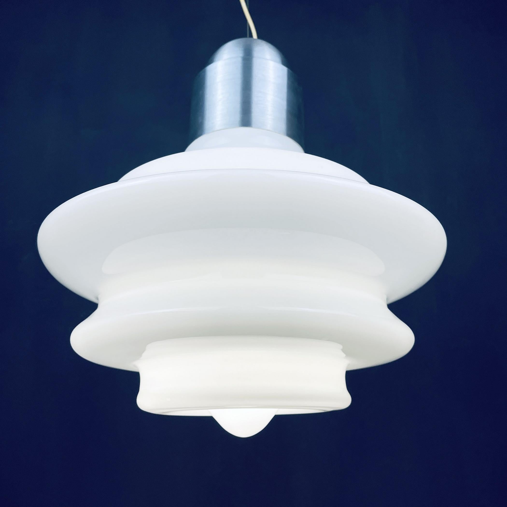 The amazing large mid-century opaline white hanging lamp was made in Italy in the 1960s.
A rather unique shaped glass that seems to fold inwards slightly at the bottom. 
 Perfect for your hallway, bedroom, entryway, or wherever you can imagine it.