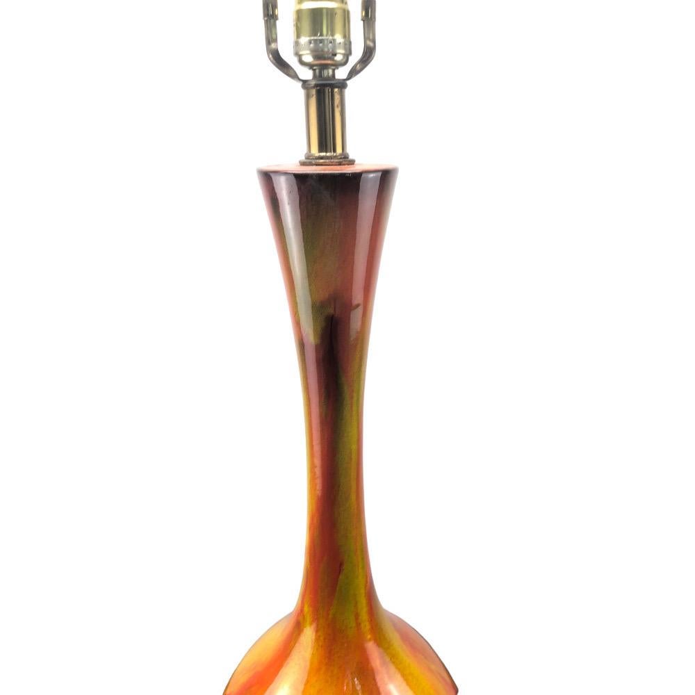 Eine große orangefarbene Tropfglasurlampe aus der Mitte des Jahrhunderts. Kräftiges Orange mit gelben und grünen Reflexen, die in die braune Basis tropfen. Fachmännisch montiert auf einem Sockel aus Messing und braunem Metall. Verkabelt und
