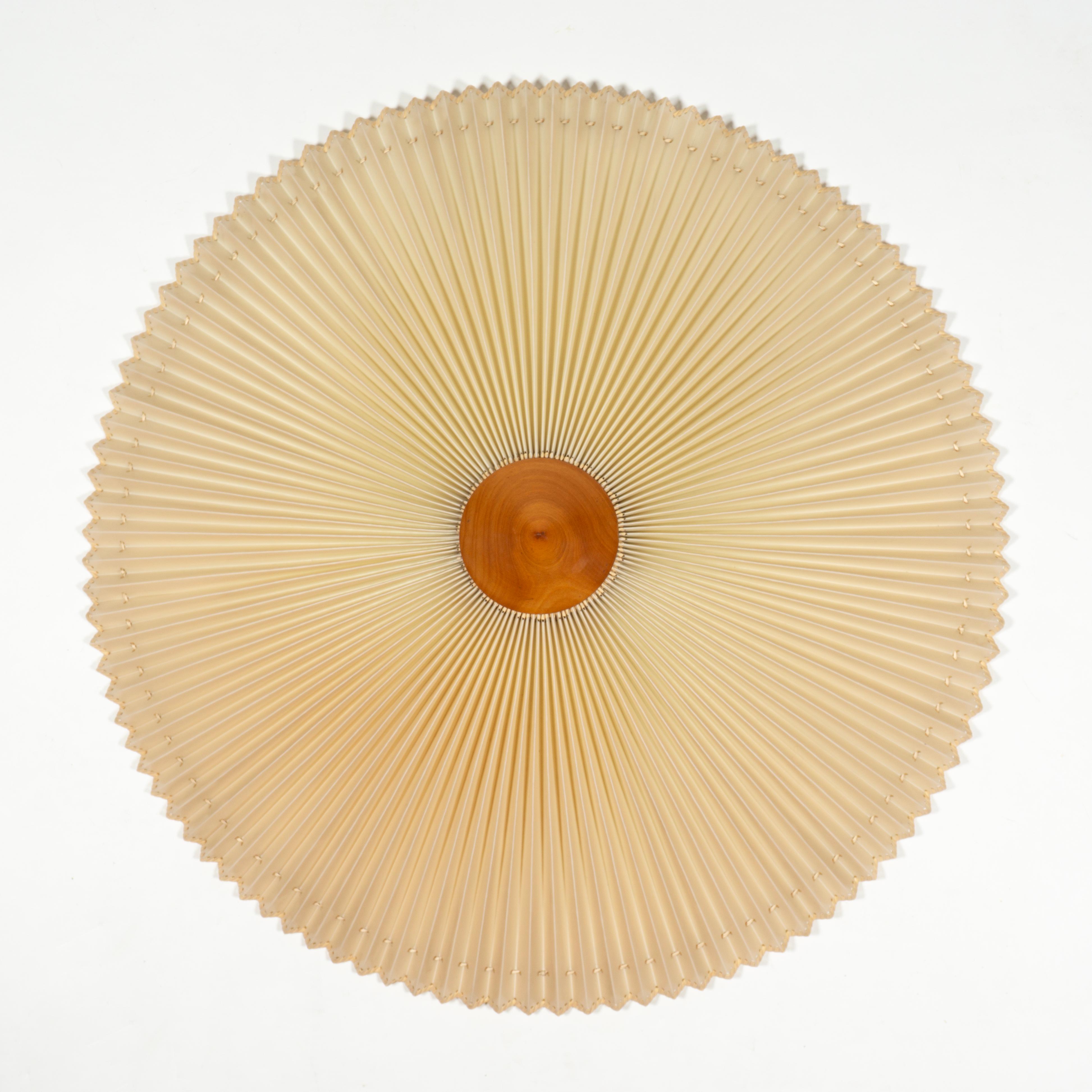 Stunning, large and highly decorative round flush mount / ceiling light from the 1960s. 
The pleated shade is made of sturdy plastic material (which makes it easy to clean) and the tip is made of turned solid wood. 
Apart from the overall beauty of