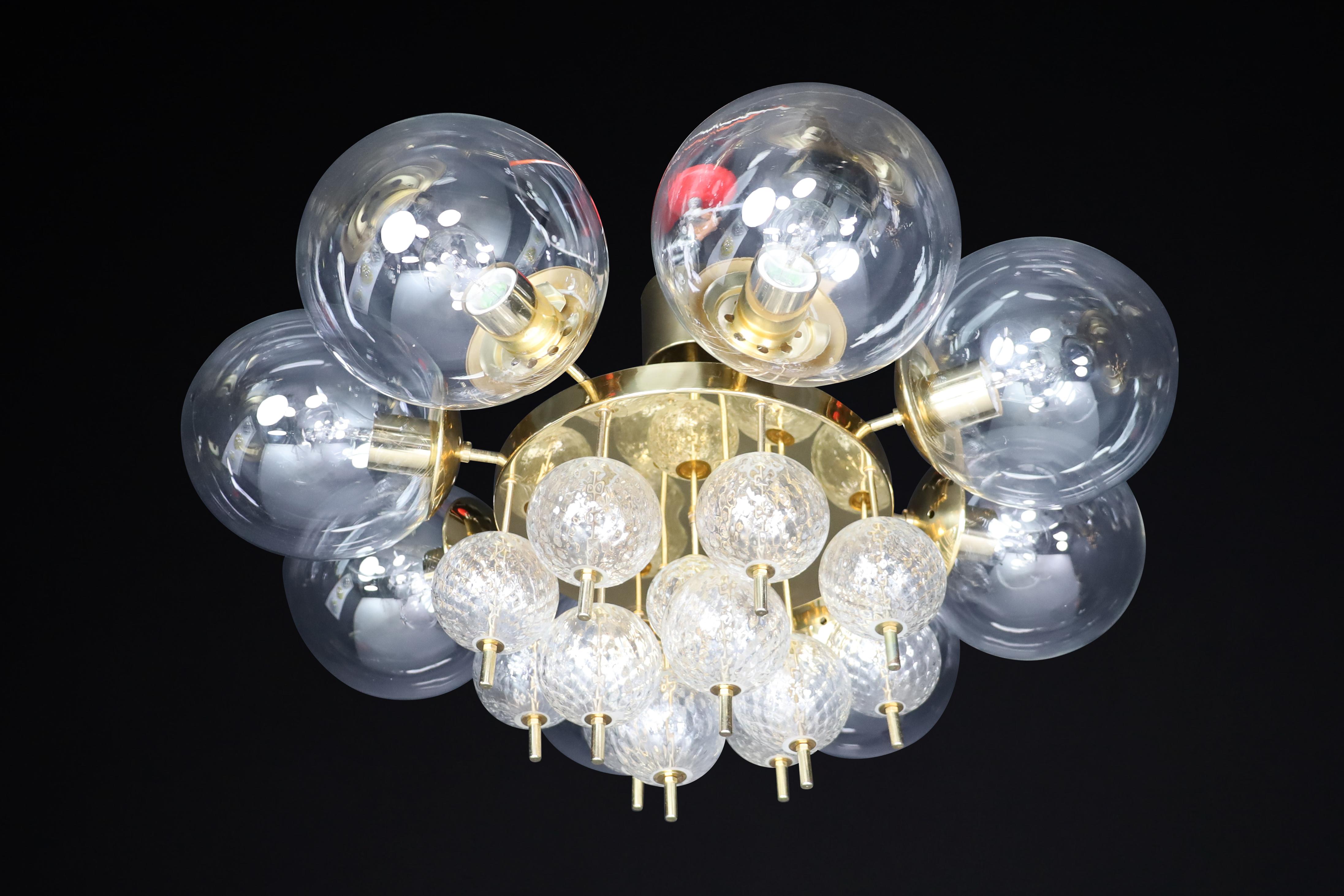 Mid-Century Brass chandelier by Preciosa in Czechia 1960s

This Mid-Century chandelier, crafted in the 1960s, boasts a brass fixture and hand-blown glass globes from the renowned Preciosa Factory in Czechia. It features eight large clear glass