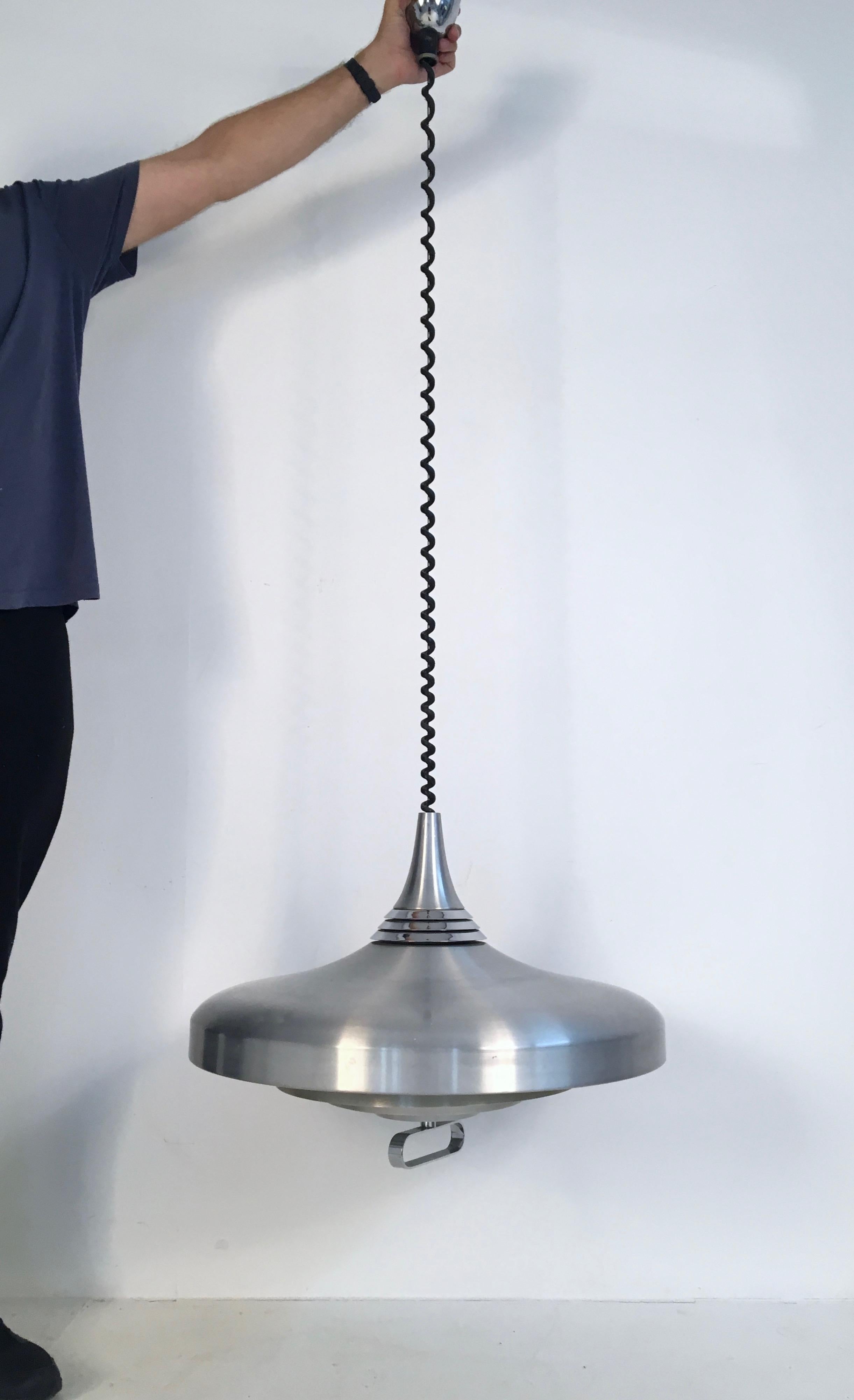 Superb, large, rise and fall aluminium pendant lamp in brushed aluminium. Approximate 70cm in diameter, the pendant pulls down to nearly 170cm. It takes 6 bulbs.

The rise and fall mechanism and lamp work perfectly. There are minor imperfections
