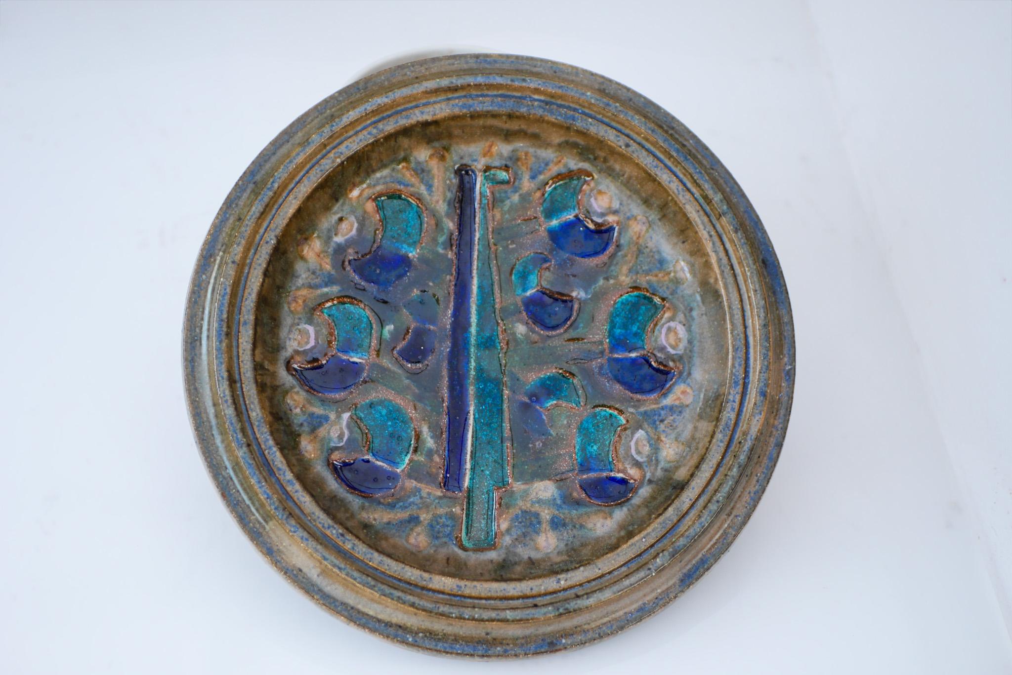 Mid-century modern signed Scandinavian art pottery wall decoration, which can also function as a large plate or bowl. This piece is known as “the Peacock” and has a very 70's feeling to it and it depicts an abstract bird in the shape of a Peacock,