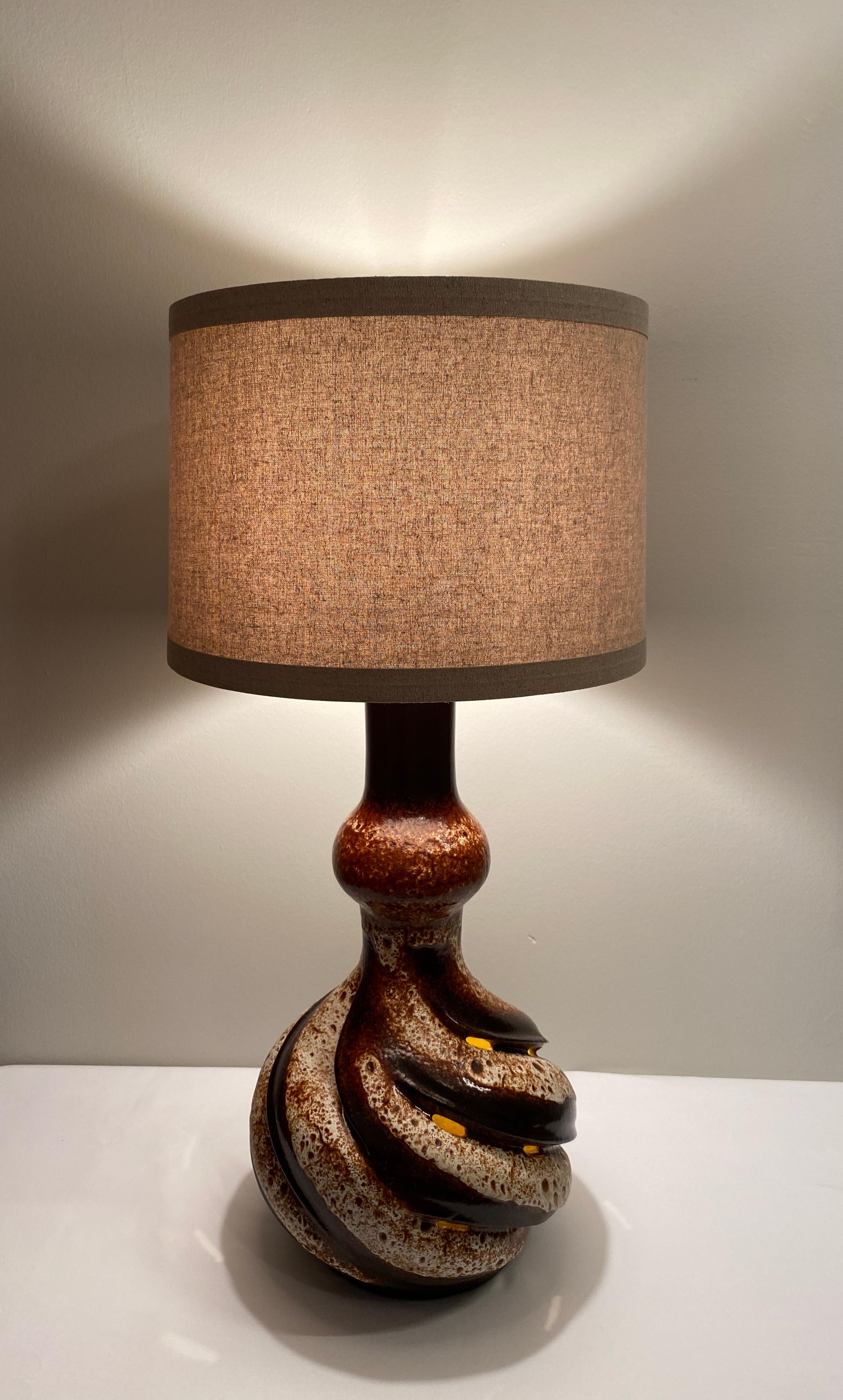 Large and very decorative table lamp from Vallauris, France. Very attractive mid-century modern ceramic table lamp with neutral colors and form. This lamp has notable sculptural work.

The muted beige and brown base has many attractive details. This