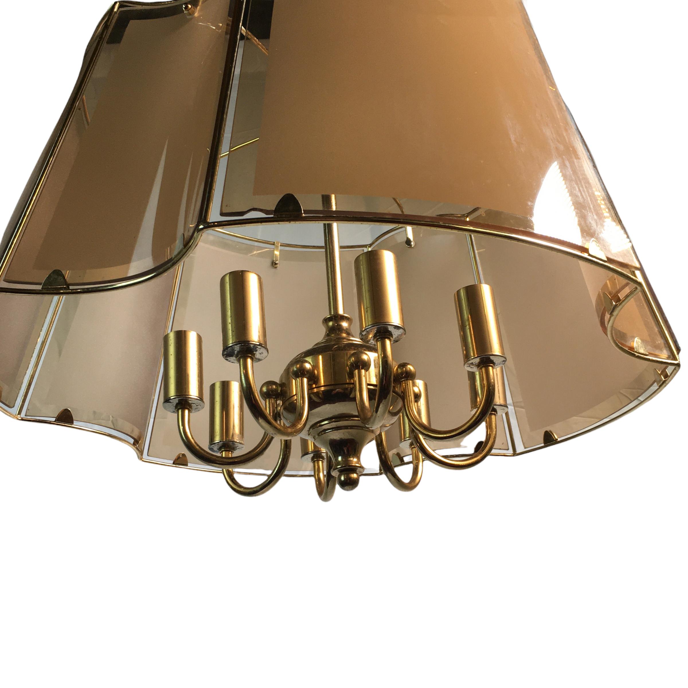A gorgeous large mid-century eight-arm brass hanging light enclosed by eight panels of graduated smoked and frosted glass. When the chandelier is switched on, it unfolds its fascinating play with light. 

The chandelier is complete with its