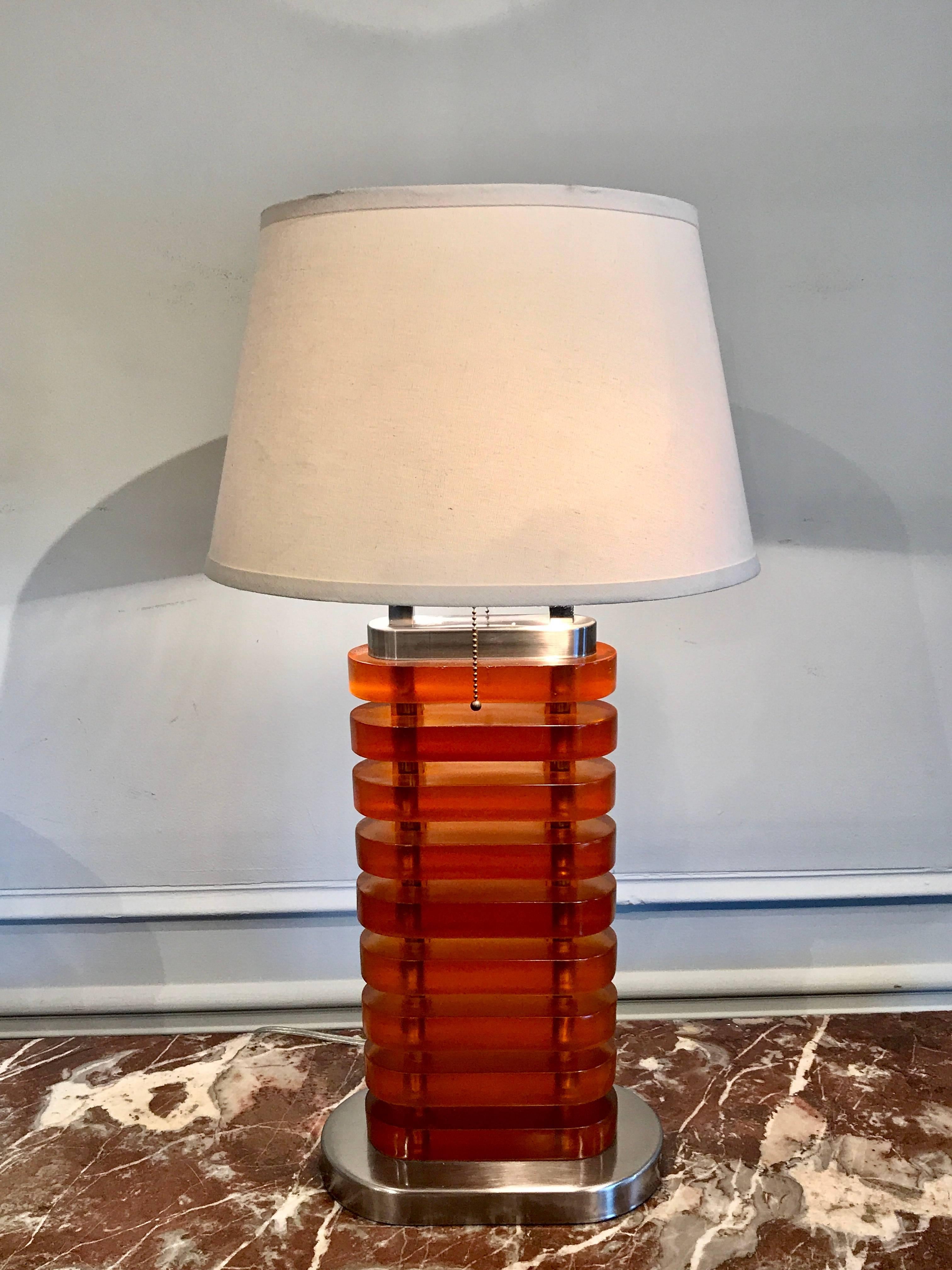 Large stacked amber Lucite lamp, consisting of nine thick oval blocks raised on a conforming base. Height of the lamp is 27