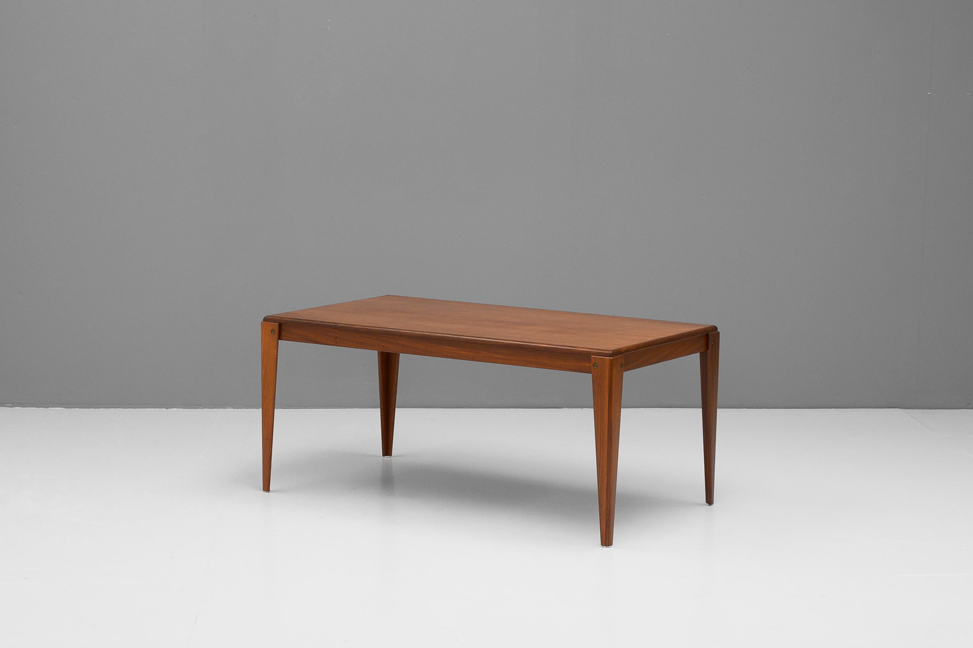 Large mid-century Swedish coffee table in teak with a shouldered leg design and brass screw details. Re-finished.