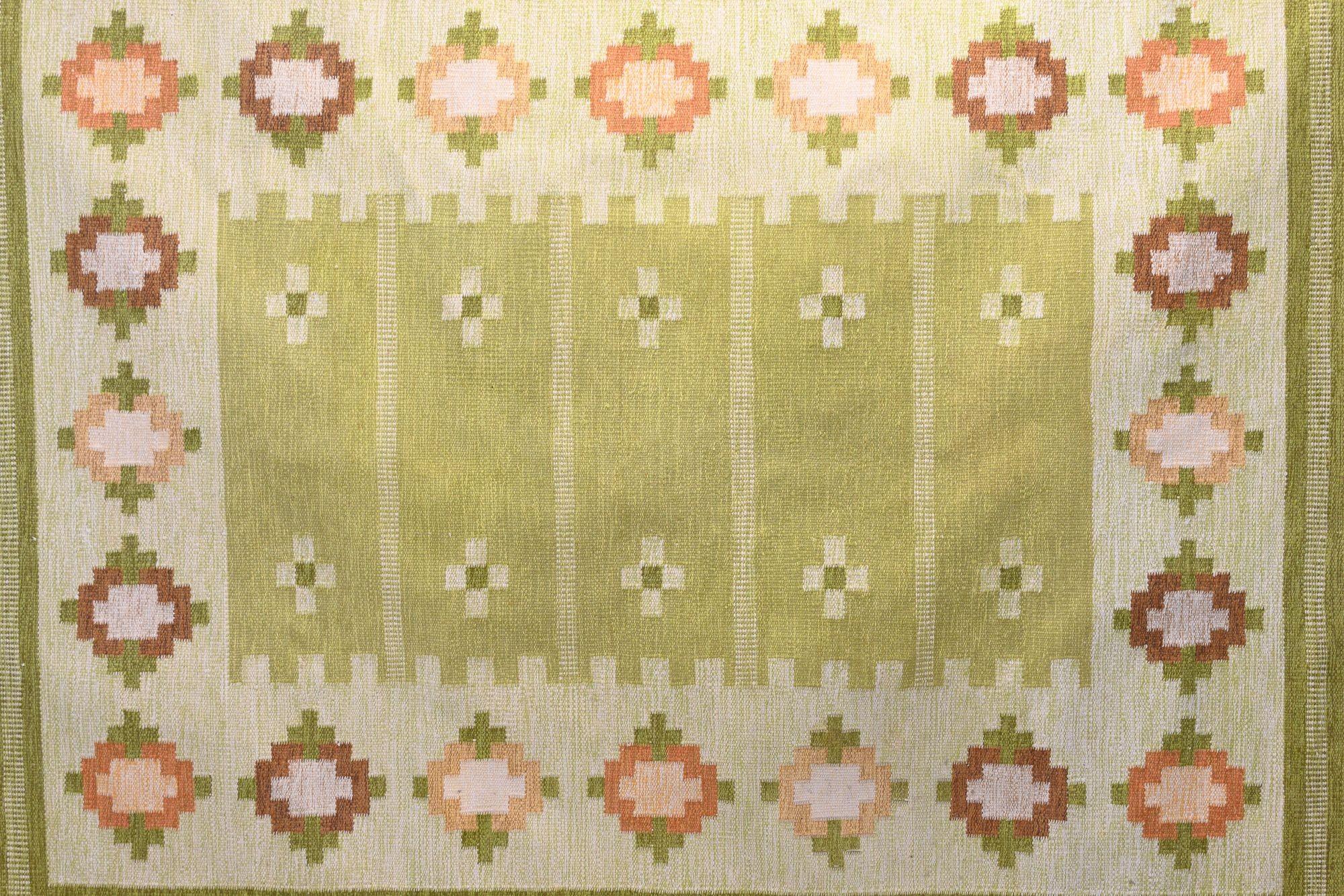 Large mid-century Swedish kilim in tones of greens and oranges. Unsigned, circa 1960. All our vintage carpets undergo a professional cleaning process. However, due to their age and previous life, some may exhibit minor signs of wear consistent with