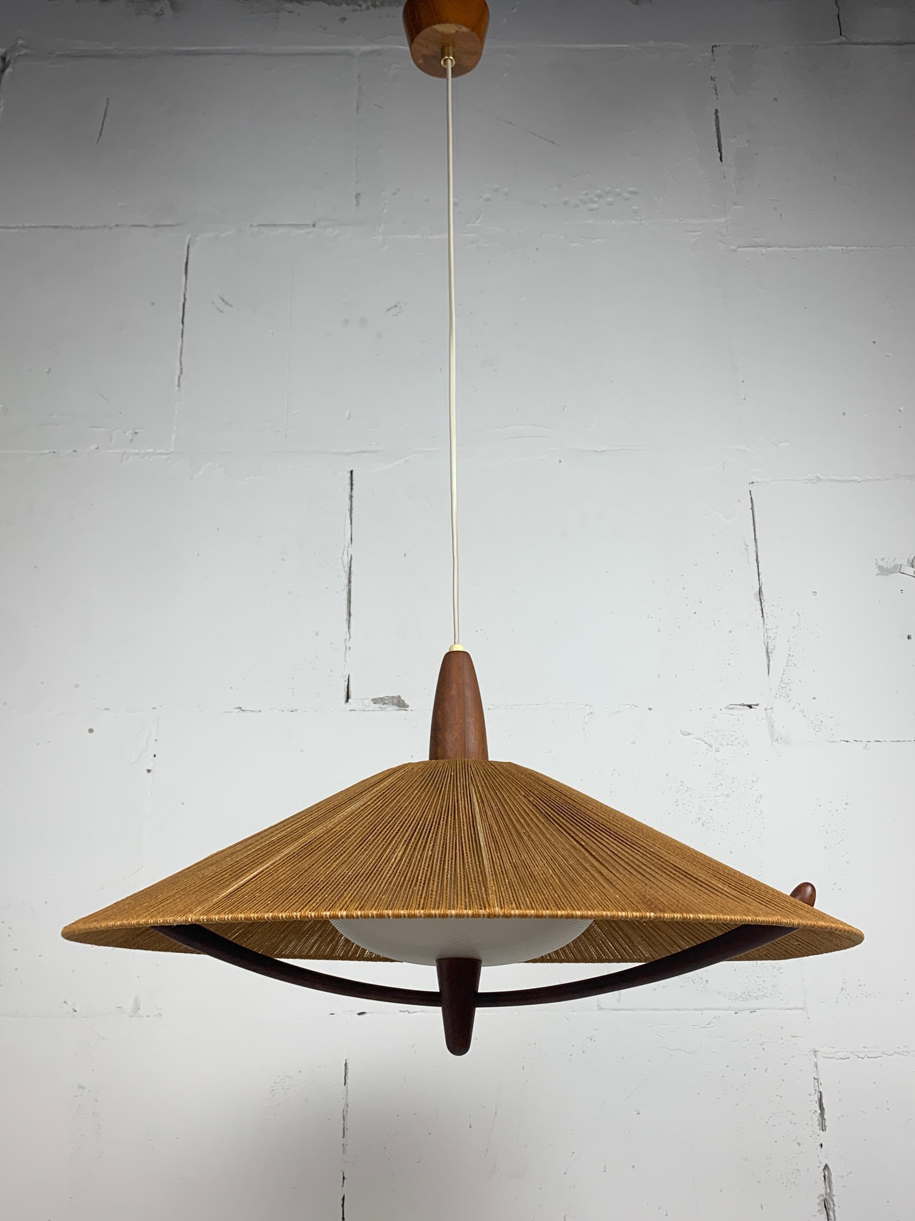 This is the extra large version ( 65 cm diameter ) of the teak sisal raffia cord hanging lamp by Temde, Switzerland 1960s. Generally you can find the 55 cm diameter ones a lot easier than this version. As can be seen the lamp is in great vintage