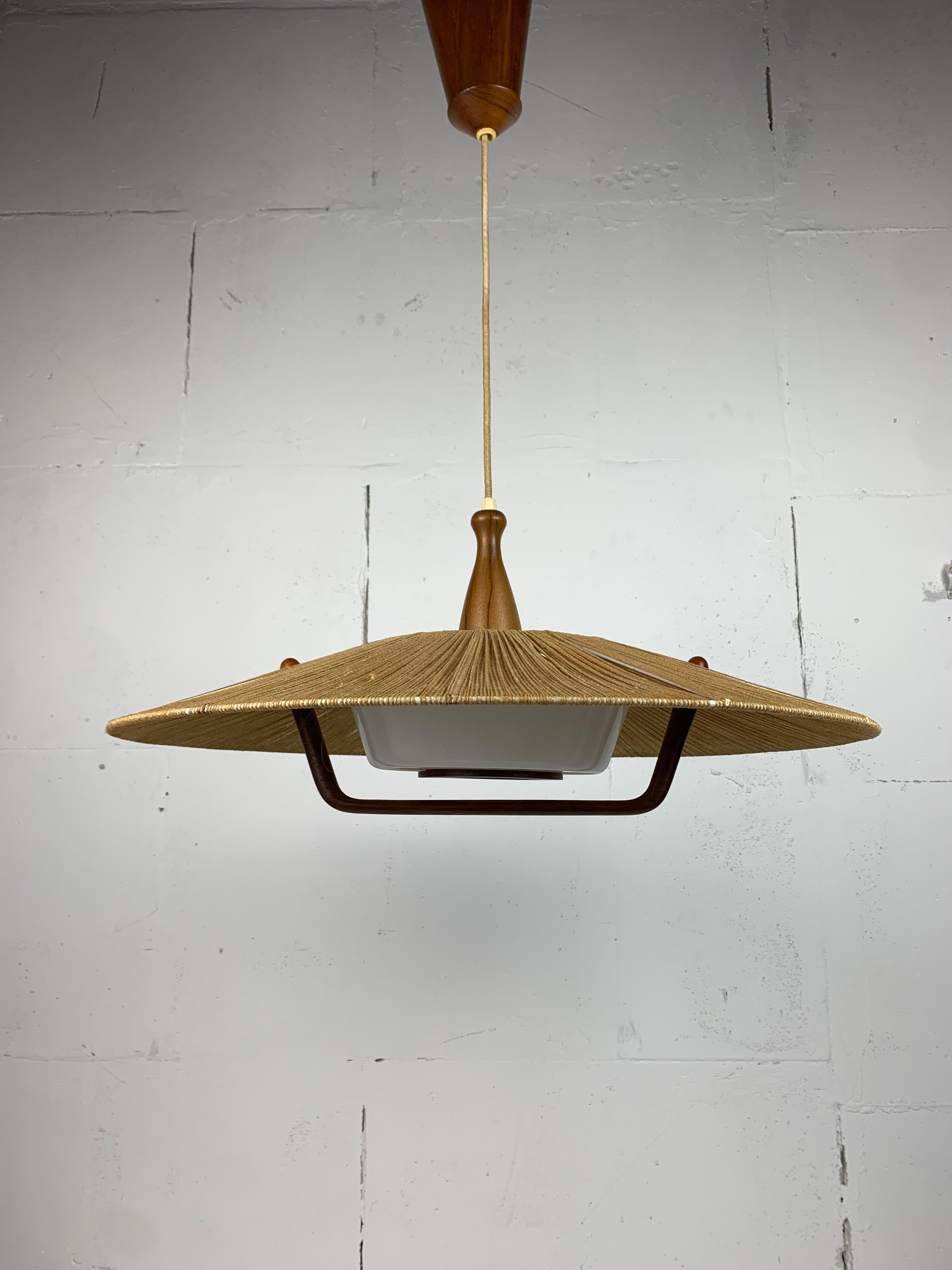 Grandi pendenti in sisal e teak di Temde, anni '60-'70. In realtà abbiamo tre pezzi di questo modello in magazzino. Gli altri due sono elencati come una coppia, poiché il raccordo in legno sopra il paralume ha una forma leggermente diversa. Questa