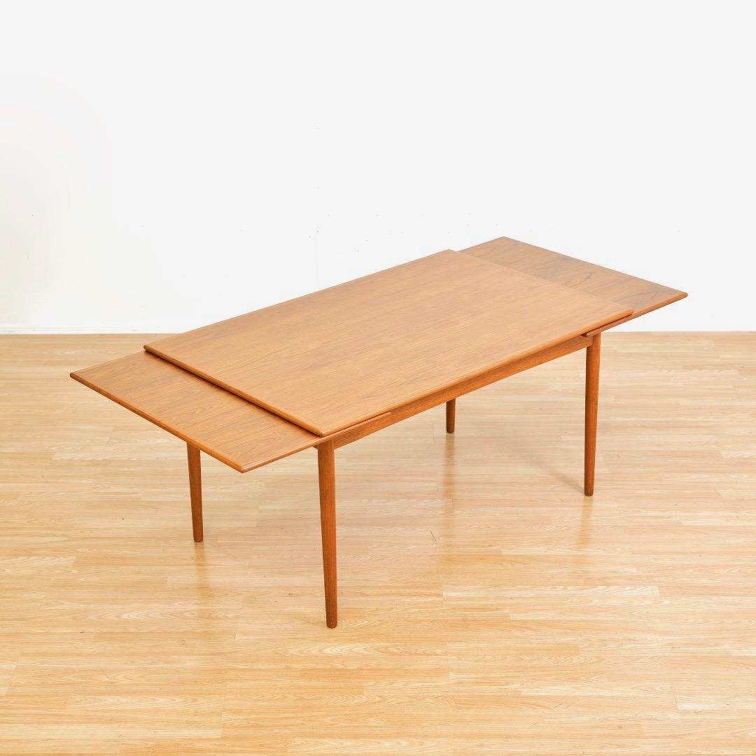 Cette grande table de salle à manger à rallonge en teck moderne danois des années 1960 a été fabriquée par Georg Petersens Mobelfabrik au Danemark dans les années 1960.  Fabriquée en teck, cette magnifique table de salle à manger est dotée de pieds