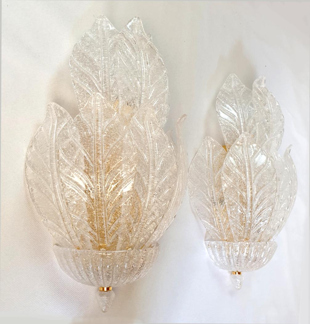Pair of large Neoclassical style Murano glass wall sconces, attributed to Barovier & Toso, Italy 1970s.
The Mid Century Modern sconces are made of translucent clear hand blown Murano glass leaves and gold plated mounts.
The vintage sconces have 3