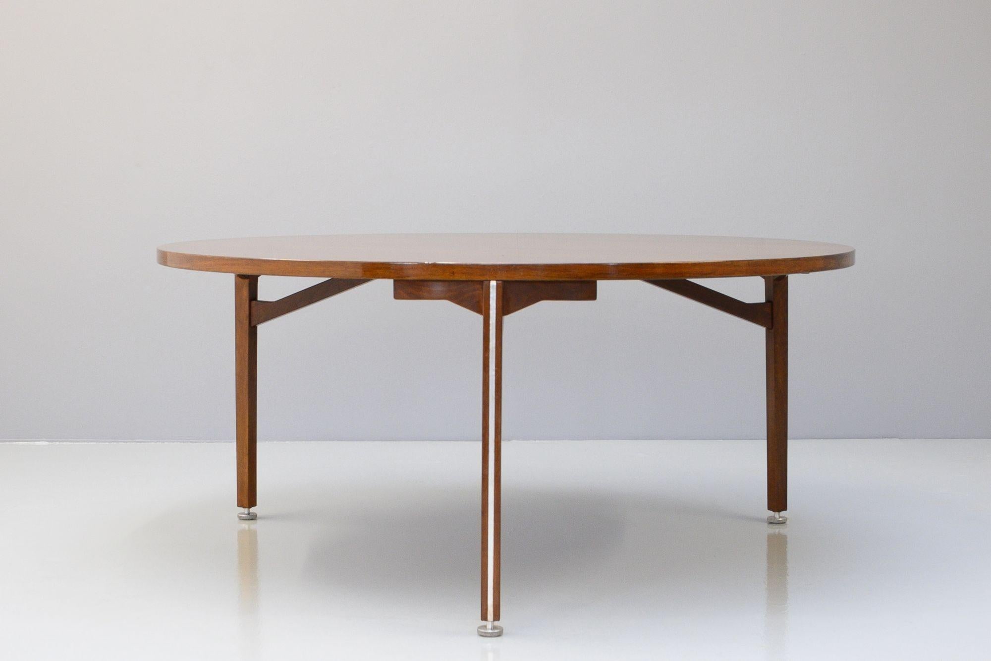 Très grande table de salle à manger circulaire du milieu du siècle en teck. Il est agrémenté d'une bande d'aluminium le long de chaque pied et de pieds réglables en fonte d'aluminium. Entièrement rénové et dans un état fantastique.