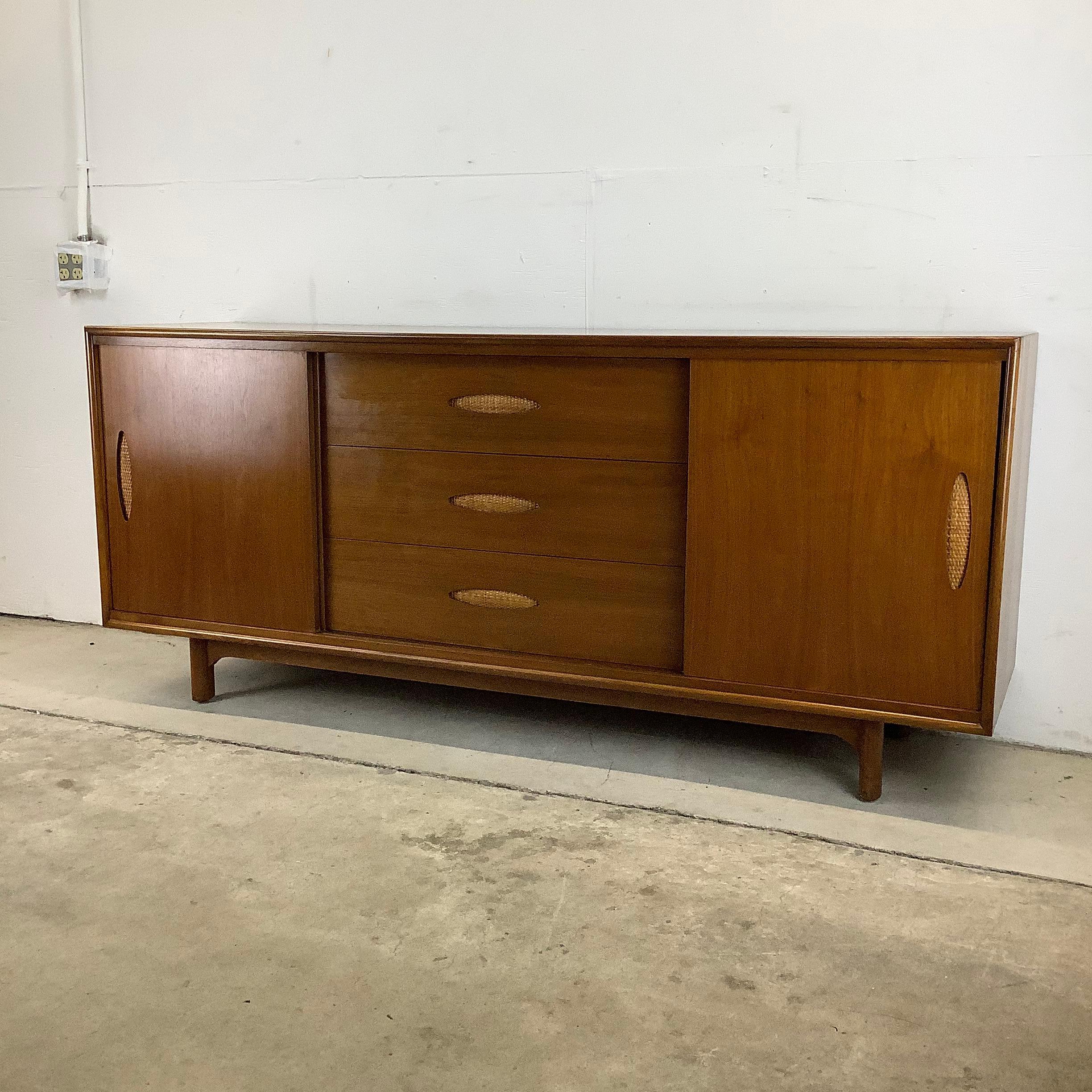 This larger scale Mid-Century Modern bedroom dresser from Cavalier furniture features a vintage walnut finish with cane front detail, heavy construction, and clean modern lines. The substantial Size and quality construction but MCM manufacturer