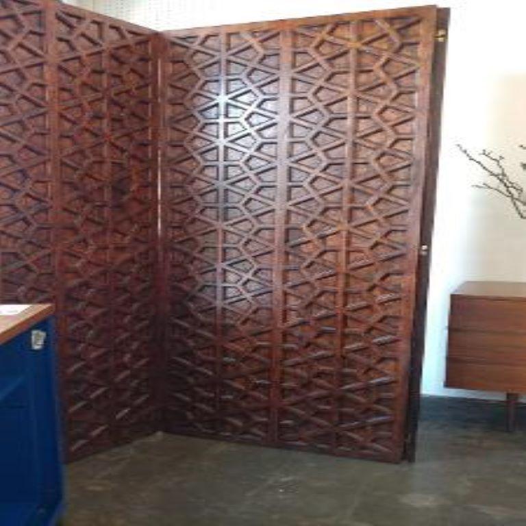 Stunning large midcentury three-panel walnut screen, room divider or privacy screen. This handsome Hollywood Regency screen has an interesting geometric design or Moroccan design that appears to be sculpted.
Our heavy substantial walnut divider