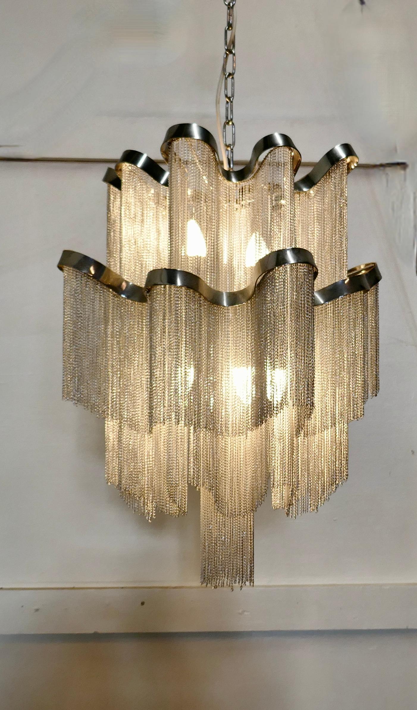 Large midcentury wavy waterfall chrome chain chandelier

This is a very unusual design the wavy waterfall tiers are hung with fine chrome chains
Inside the pendant takes 6 bulbs giving a very pleasant bright light
All in good working