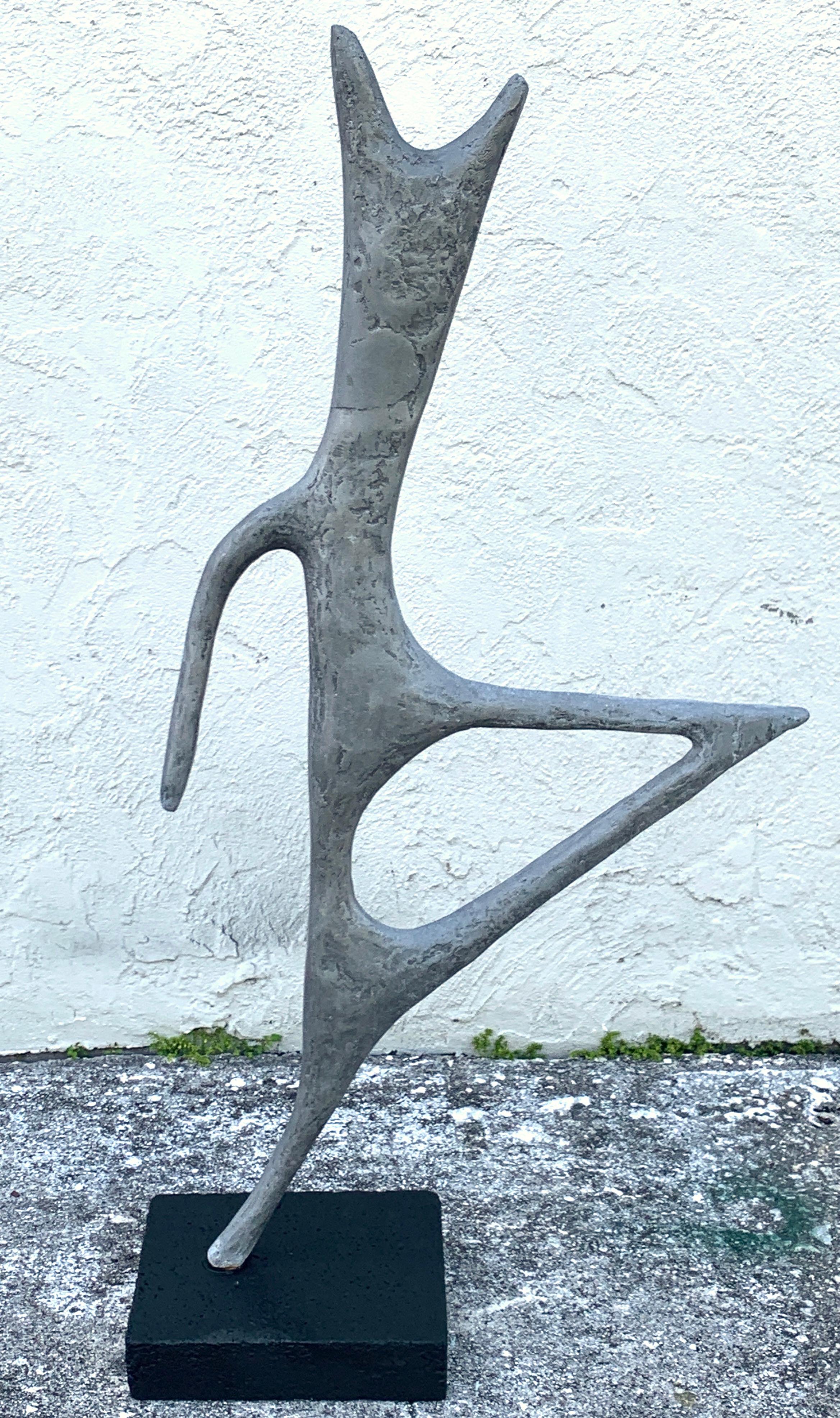 Large midcentury zinc abstract garden statue by JH Zimmerman. 1962, retaining the original patina, raised on a ebonized cast stone plinth base. The sculpture does not separate from the base. Can be used outdoors or indoors.
