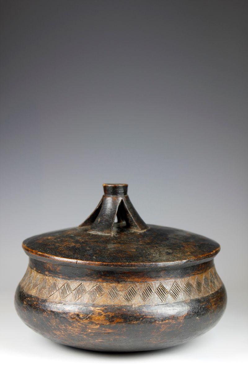 Carved from a hard, dense wood, this large traditional food bowl from the Lozi culture in Zambia displays a beautiful round form.  A band of diamond-shaped designs, each decorated with a series of incised striations, adorns the outer perimeter of