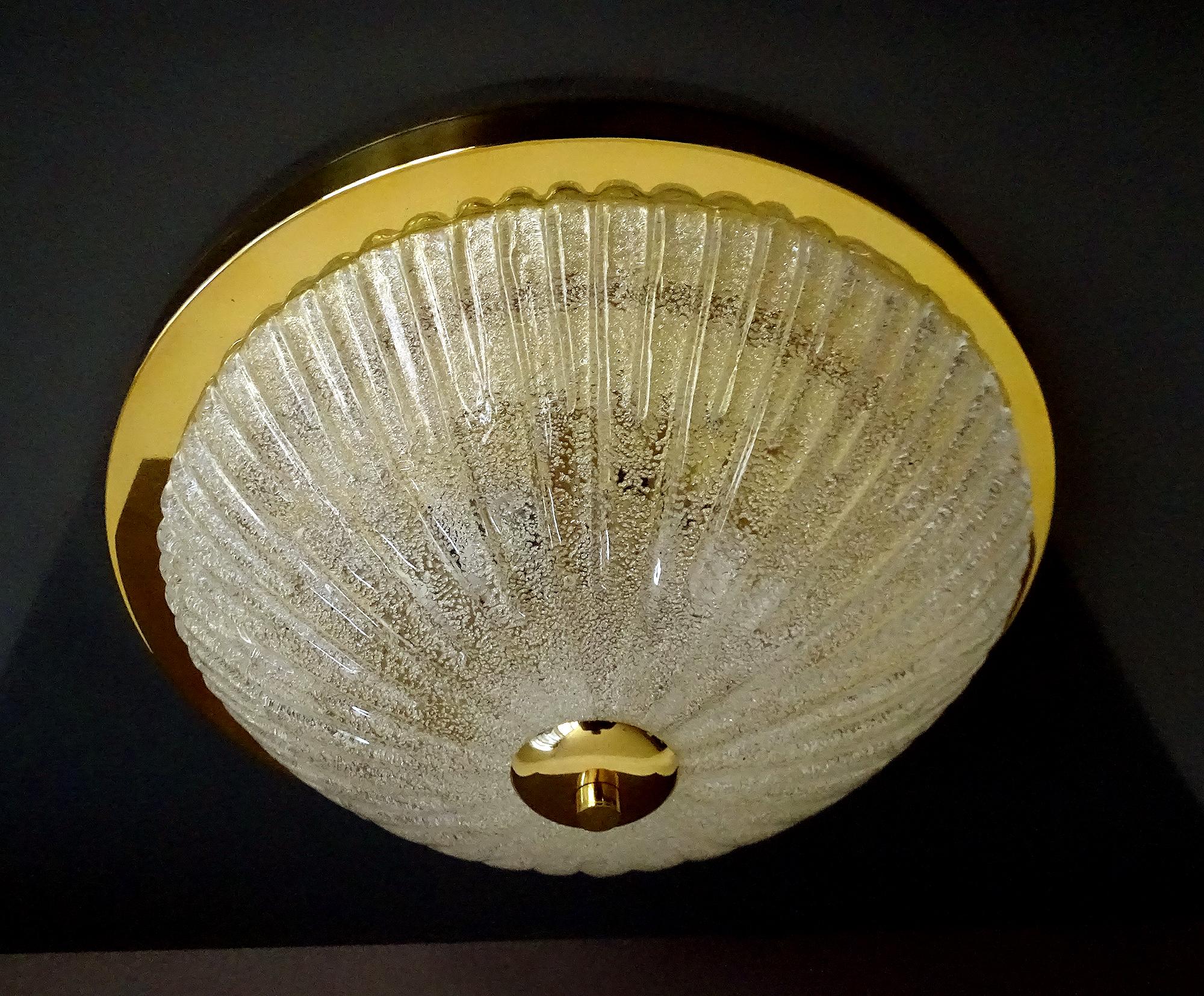 Large midcentury glass flush mount light in the manner of Barovier Toso, ribbed glass with small inclusions, brass base.
7.48 in.H / 19 cmH
Diameter
16.54 in. (42 cm)
Three standard size bulbs 60 watts each


The stylish elegance an design suits 