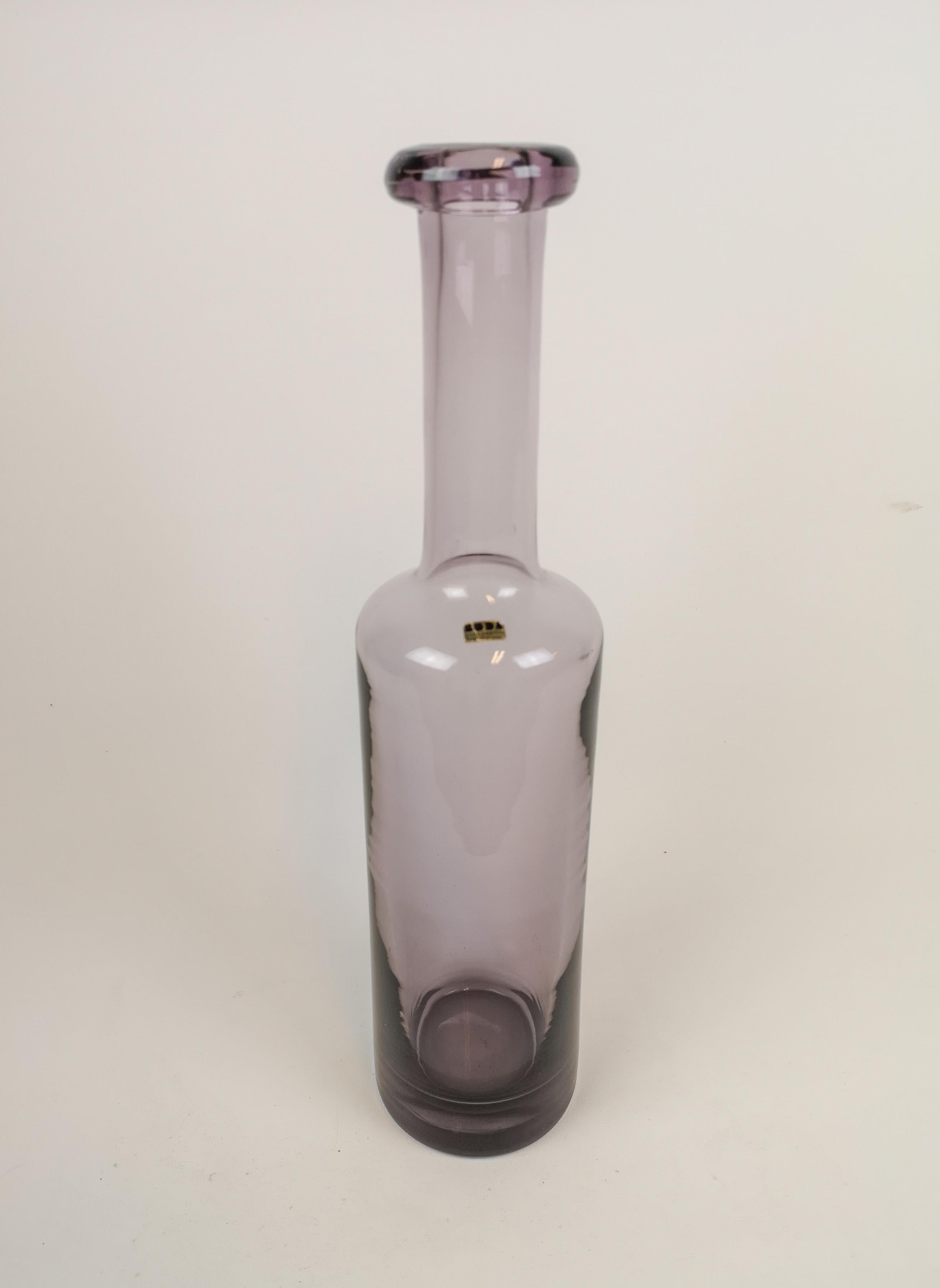 This large bottle was made at Boda and designed by Erik Höglund in Sweden, 1960s.
The bottles light purple color gives the glass that wonderful art shine. It’s a large piece consider its form as bottle. 

Very good condition. 

Measures: H 42,