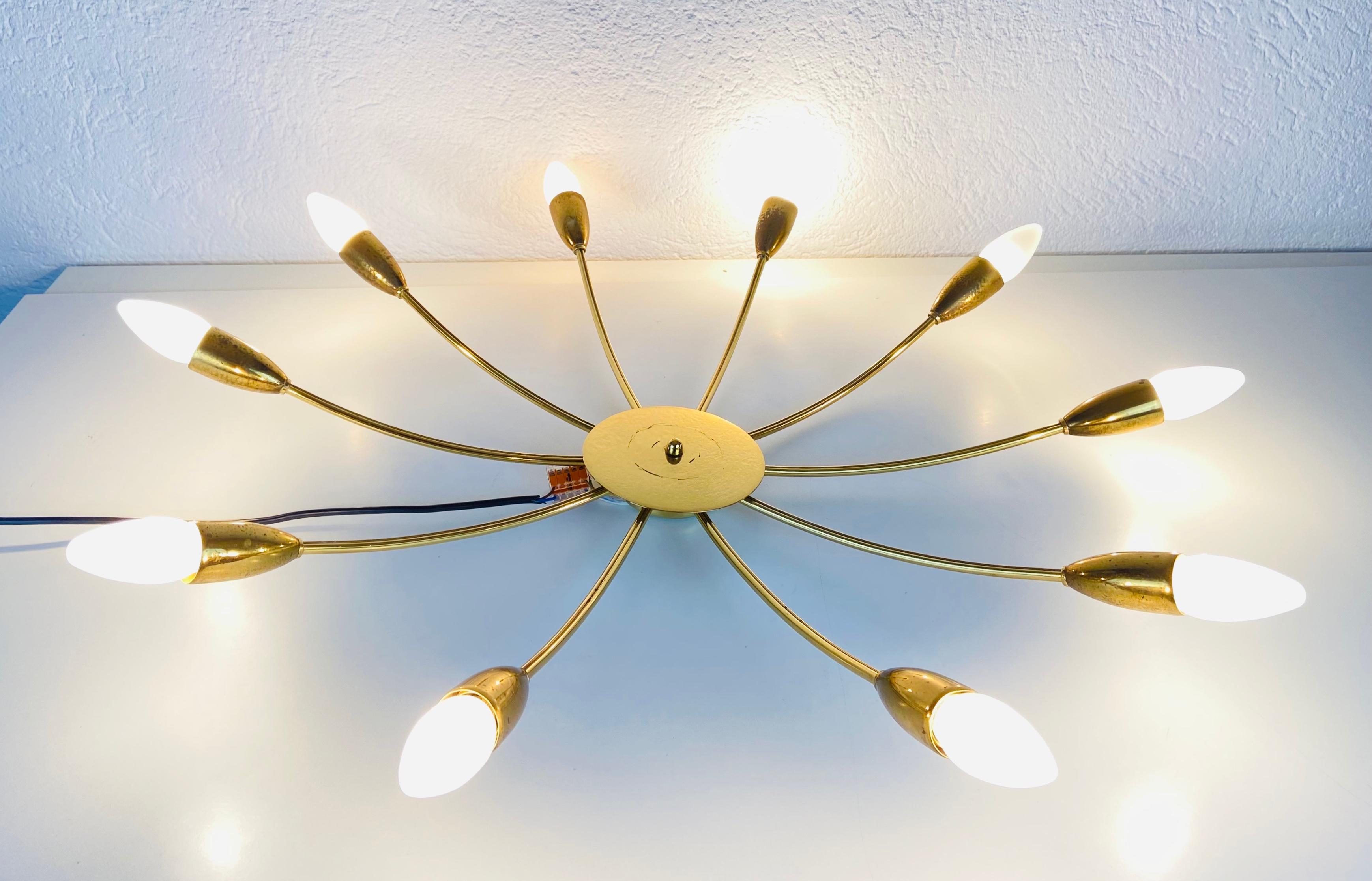 A Sputnik chandelier made in Germany in the 1950s. It is fascinating with its ten brass arms, each of it with an E14 light bulb. The shape of the light is similar to a spider.

The light requires 10 E14 light bulbs. Works with both 120/220 V. Good