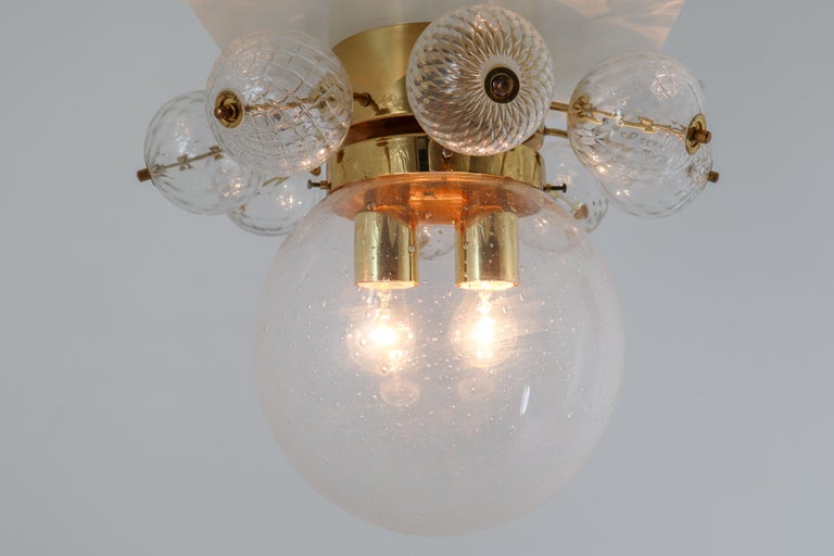 Large ceiling lamp chandeliers with brass base and large hand blown glass globe. The lights are beautifully decorated thanks to the structured glass. The pleasant light it spreads is very atmospheric, these large ceiling lamp-chandeliers will