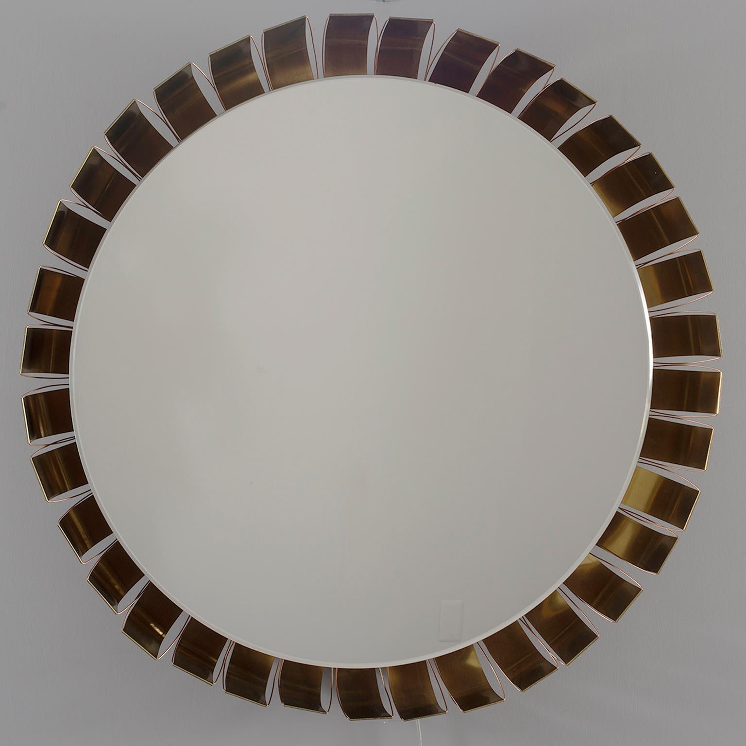 Round wall mirror has frame of bronze colored metal petals and is back lit, circa 1960s. Mirror only portion is 29” diameter. Unknown German maker. All wiring has been updated for US standards.