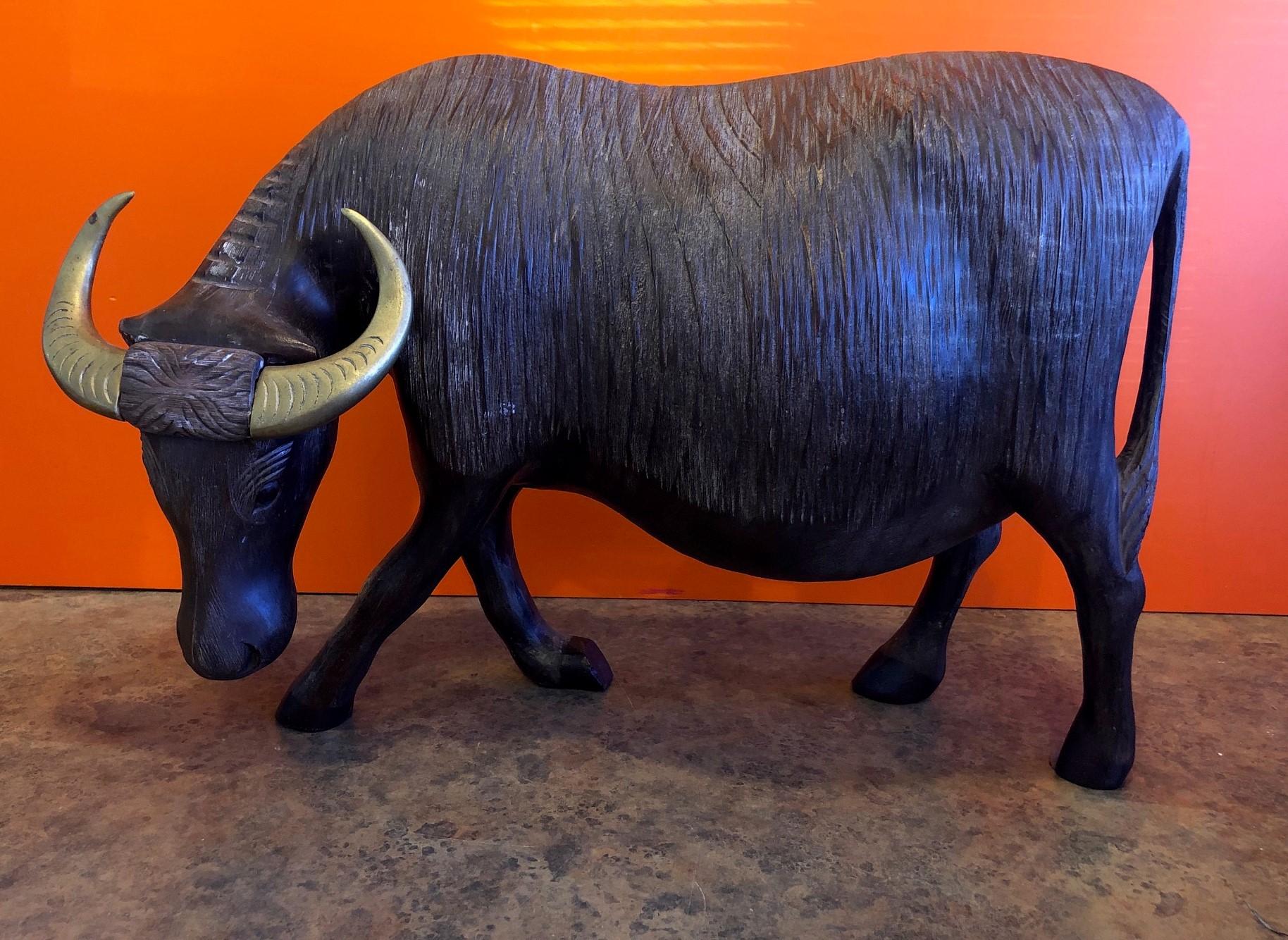 Impressive midcentury carved wood charging bull with brass horns from Mexico, circa 1970s. The piece is finely carved with intricate detail and has great color and patina.