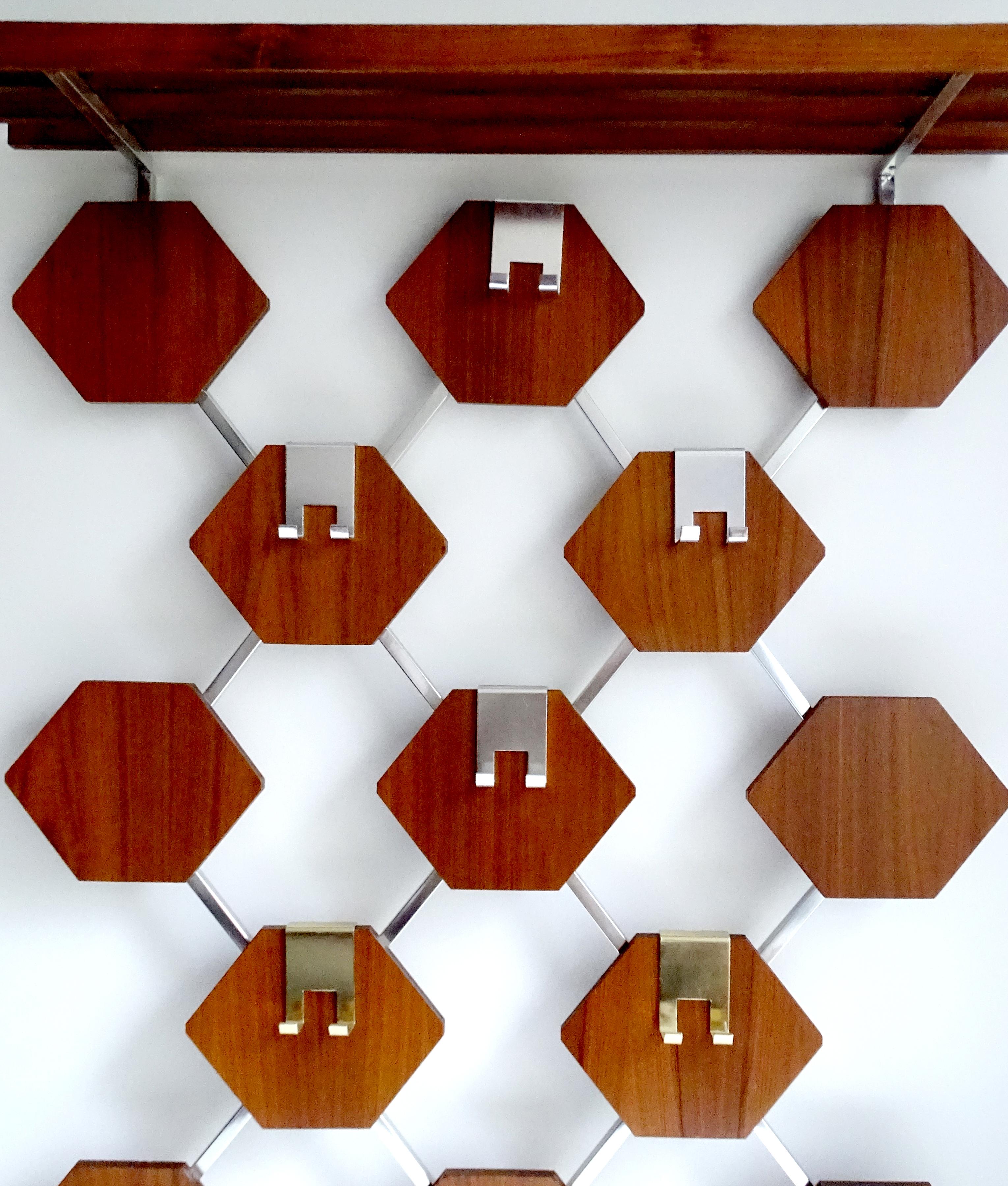 Very large Danish modern midcentury coat rack with an exceptional design, airy frame with 13 hexagonal wooden cut-out veneered with teak, six aluminum hooks (2 gold anodized) for clothes and bags (or children coats), it comes with an integrated hat