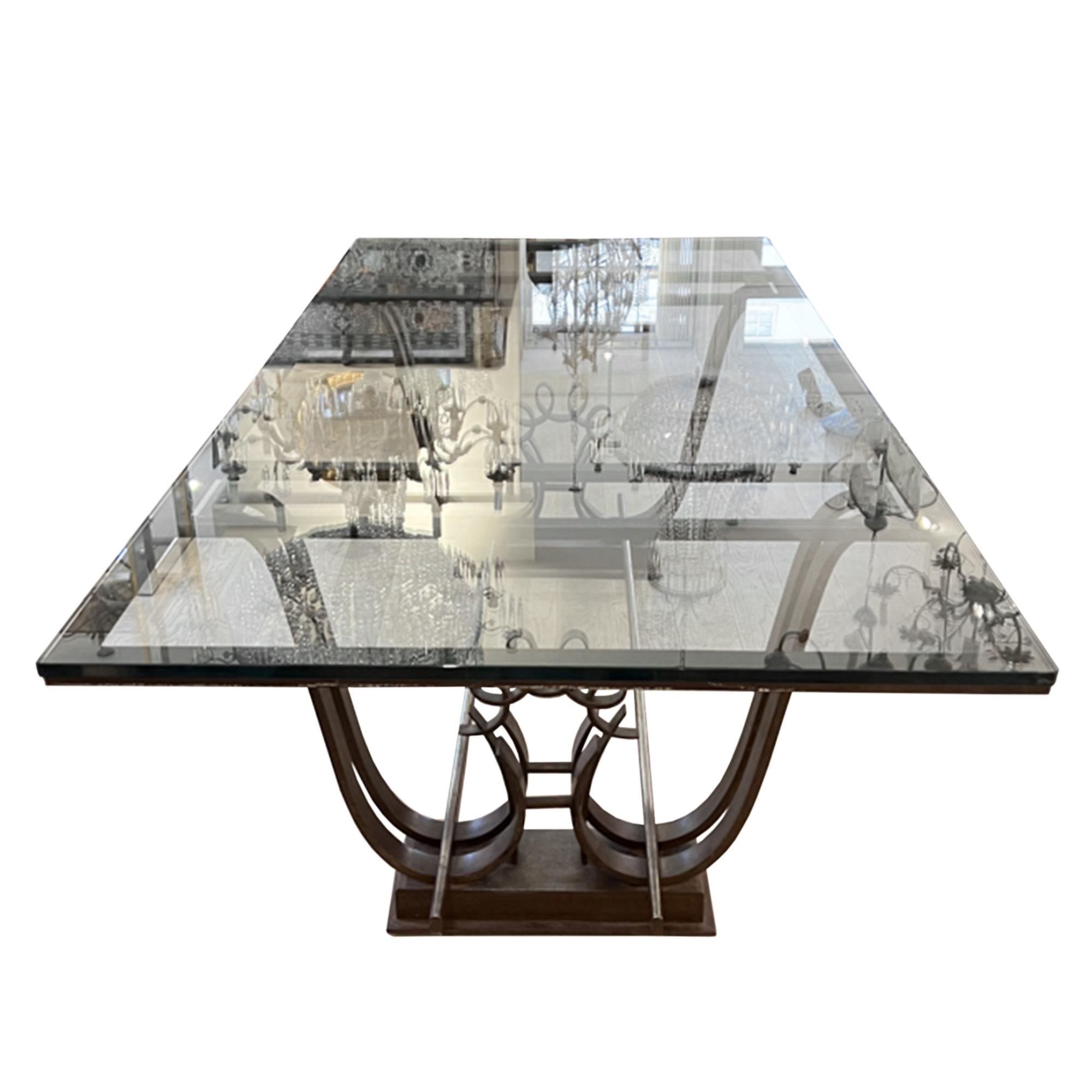 This fabulous dining table was made in France in the 1950s and is attributed to Raymond Subes.

Crafted from wrought iron with a glass top - please take a look at all our pictures to see the decorative design on the base.

This table is very heavy.