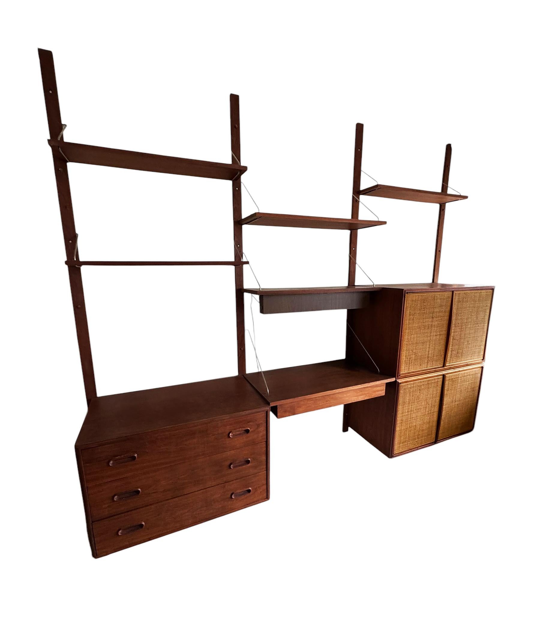 Here we have a large wall unit designed by Jack Cartwright for Founders Furniture. Consists 4 modular shelves, 3 large modular cabinets (two in cane), 1 modular desk drawer with writing area, 1 modeular work light. All pieces can be configured to