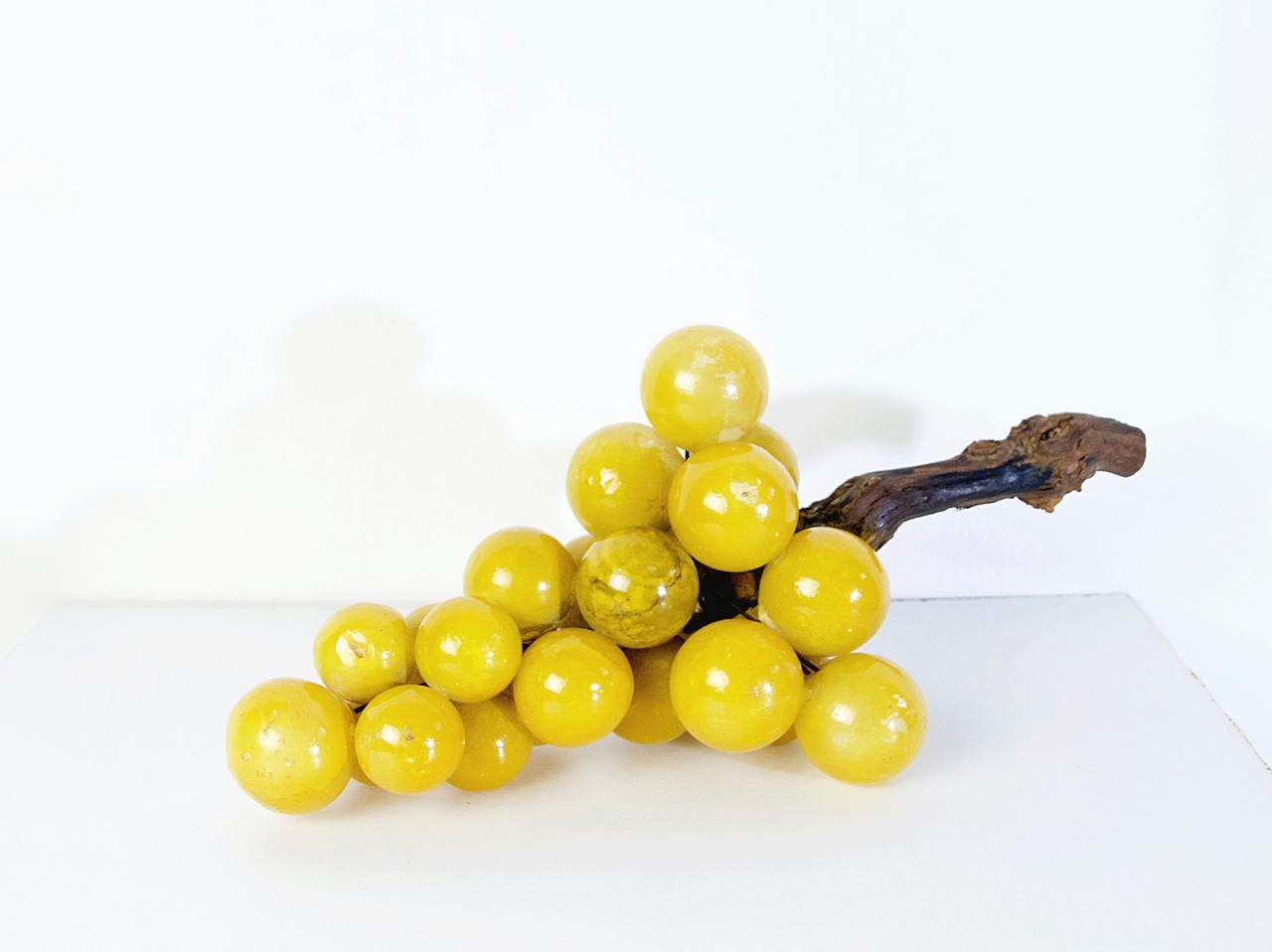 A really large original midcentury decorative yellow cluster of grapes in painted alabaster with an olive branch for stem.