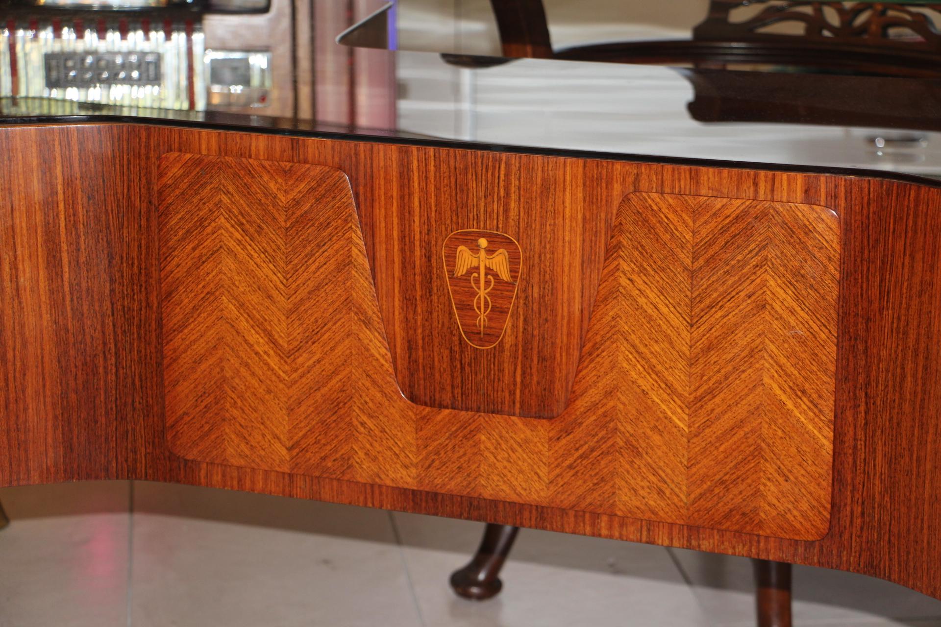 This impressive executive desk by the 1950s Italian designer, Vittorio Dassi, features a very comfortable 1.5 cm thick floating glass top, underneath, there is another very thick piece of brown glass then two columns of two sturdy drawers. Solid