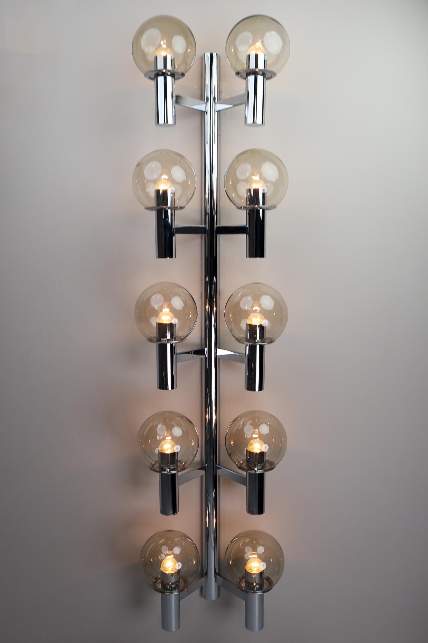 Large midcentury modern chrome wall lights- sculptures produced in Italy 1970s. The pleasant light it spreads is very atmospheric, these wall scones or fixtures will contribute to a luxurious character of the (hotel-bar) interior. Perfect original