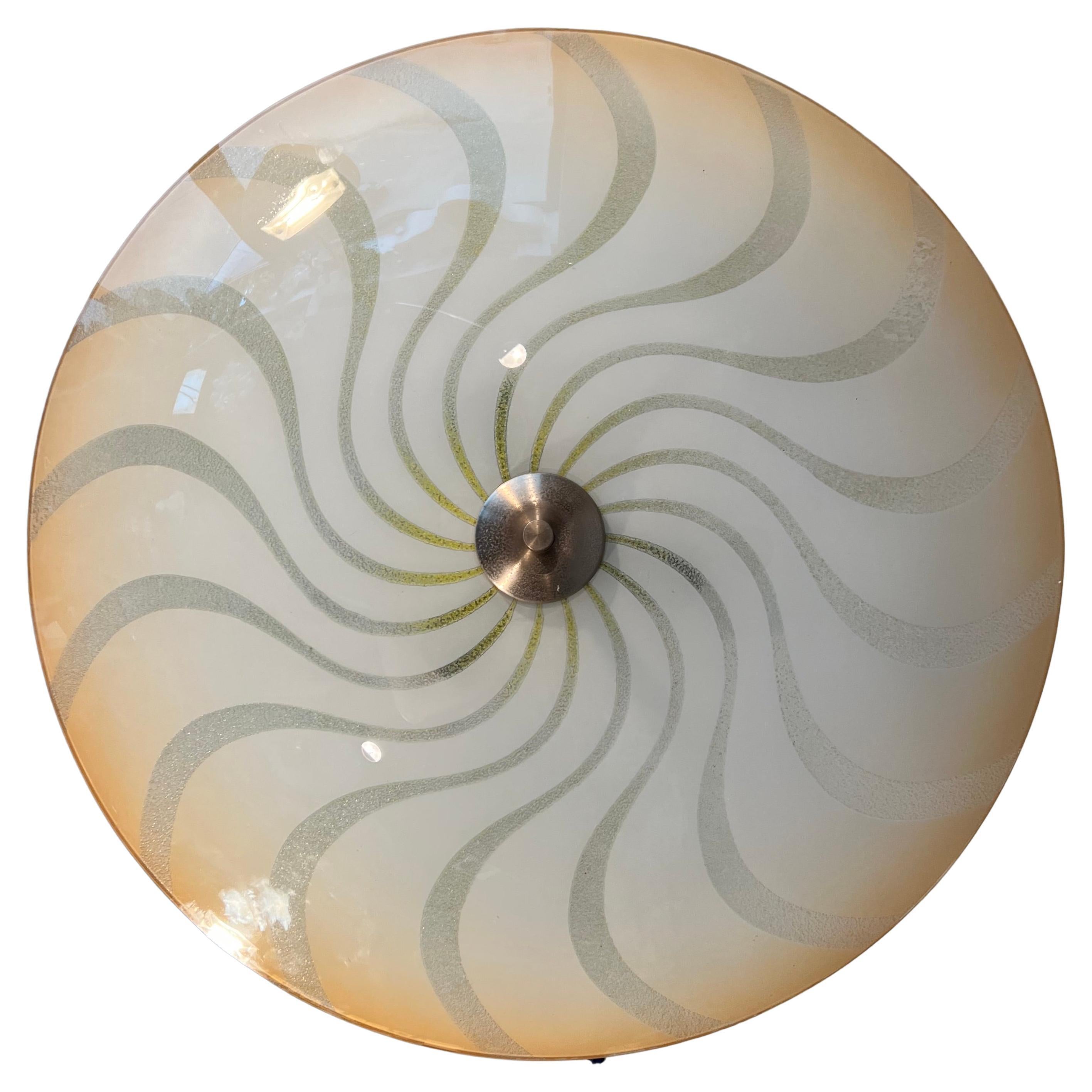 Beautiful shape AND materials flush mount from the Mid-Century Modern era.

This rare shape and large size flush mount has a stunning, glass shade with a striking, hurricane or vortex-like pattern. As you can see, the artistic and almost flat glass