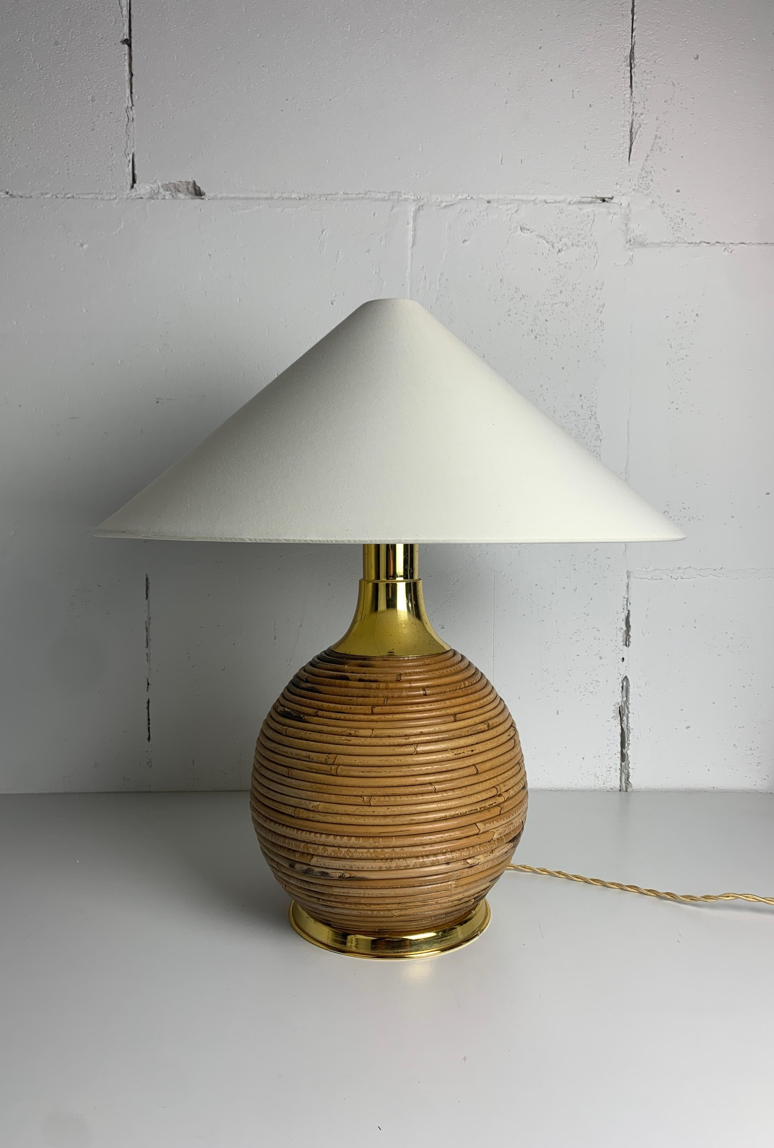 Magnifique lampe de table en rotin roseau et laiton. Cette lampe sera livrée avec son nouvel abat-jour comme indiqué sur les photos. La lampe est prévue pour une ampoule E27. Nous avons actuellement deux de ces versions plus grandes ( nous avons