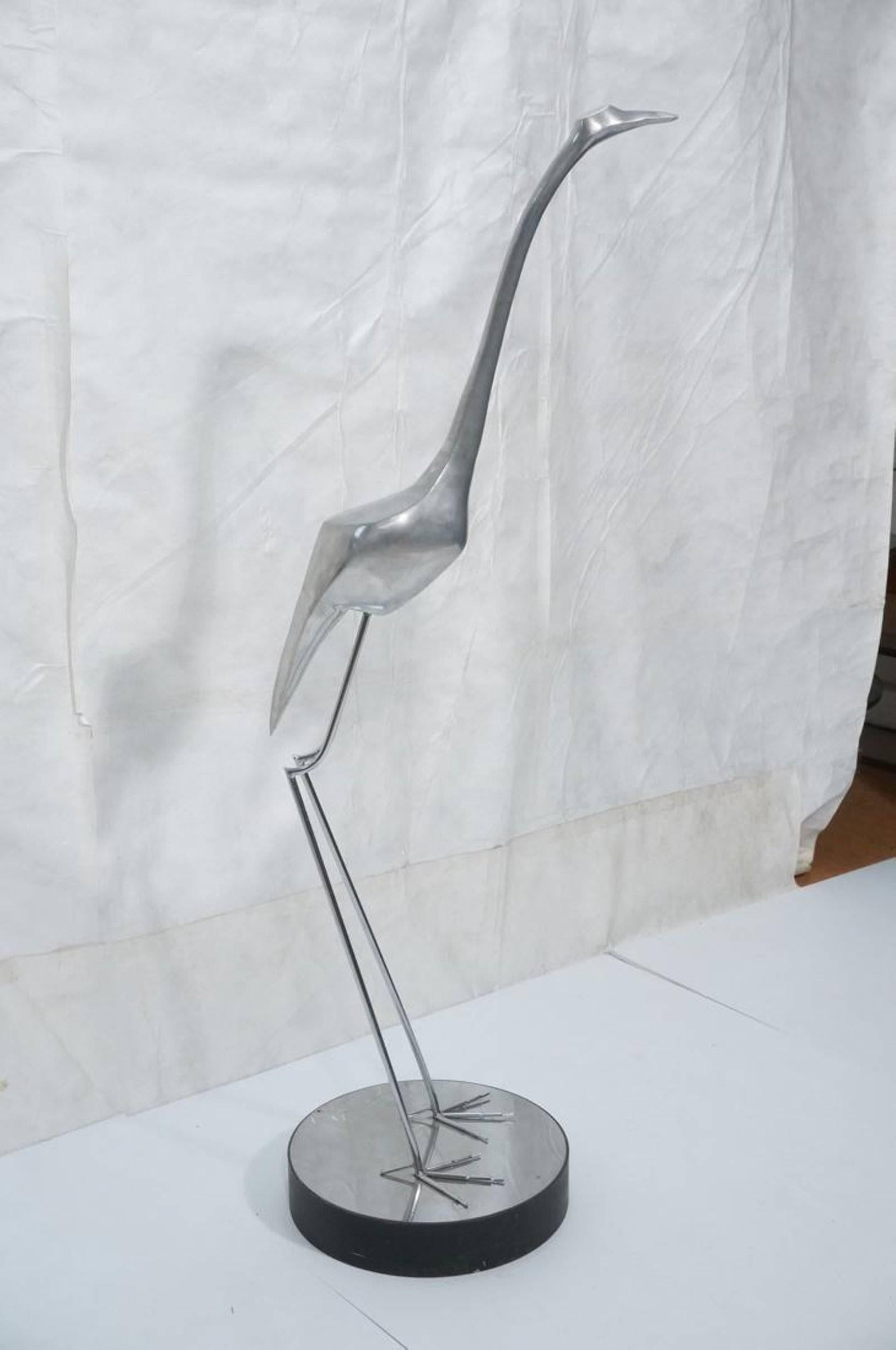 Large midcentury sculpture of a standing egret, in the style of Maison Jansen, raised on a circular enameled base.