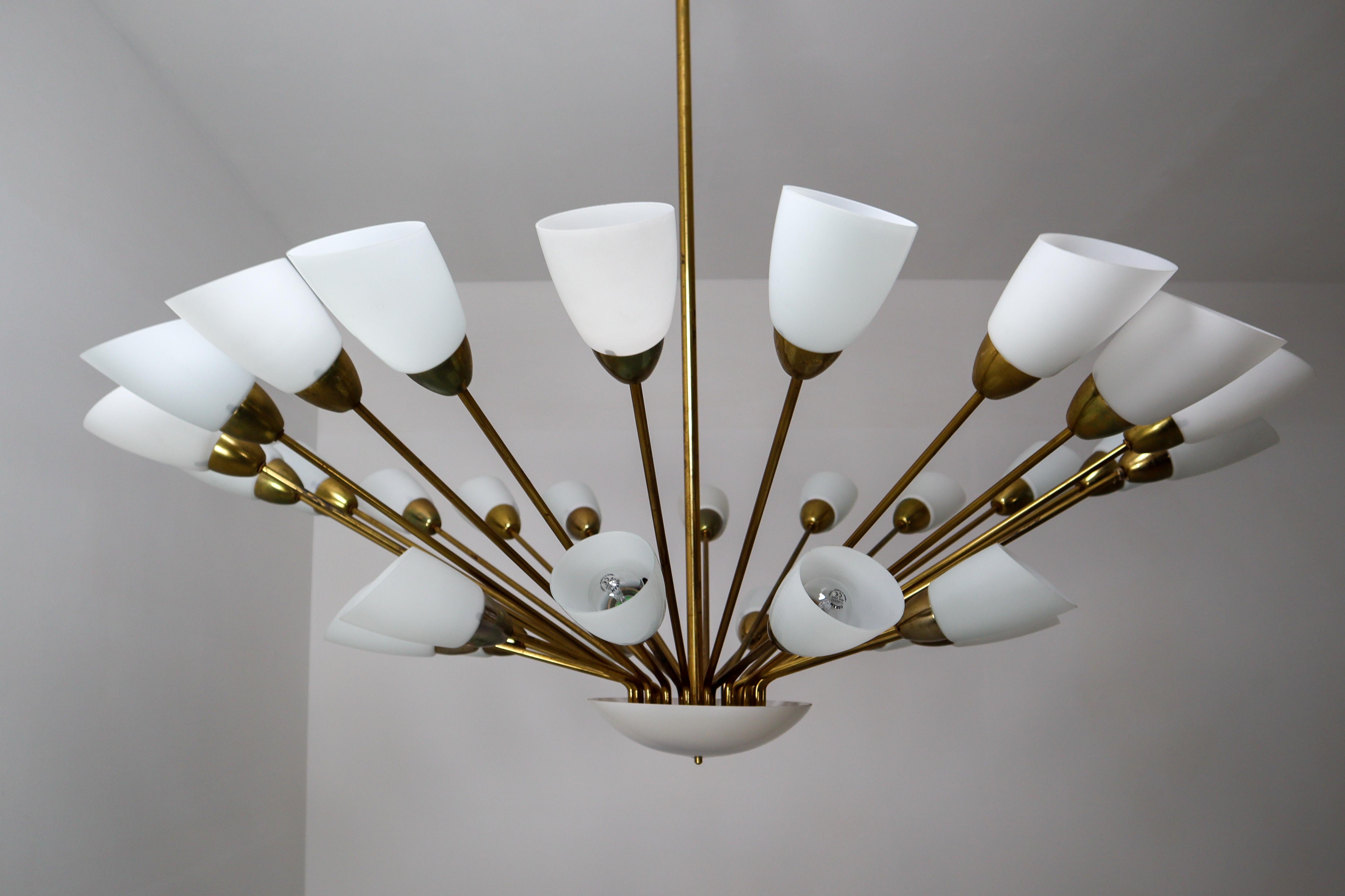 This unique midcentury modernist Sputnik features a sculptural spider form design on a brass frame with 30 (E27) sockets and holds 30 white opaline glass shades. Made in Austria, manufactured, circa 1950s. The chandelier with brass frame consist of