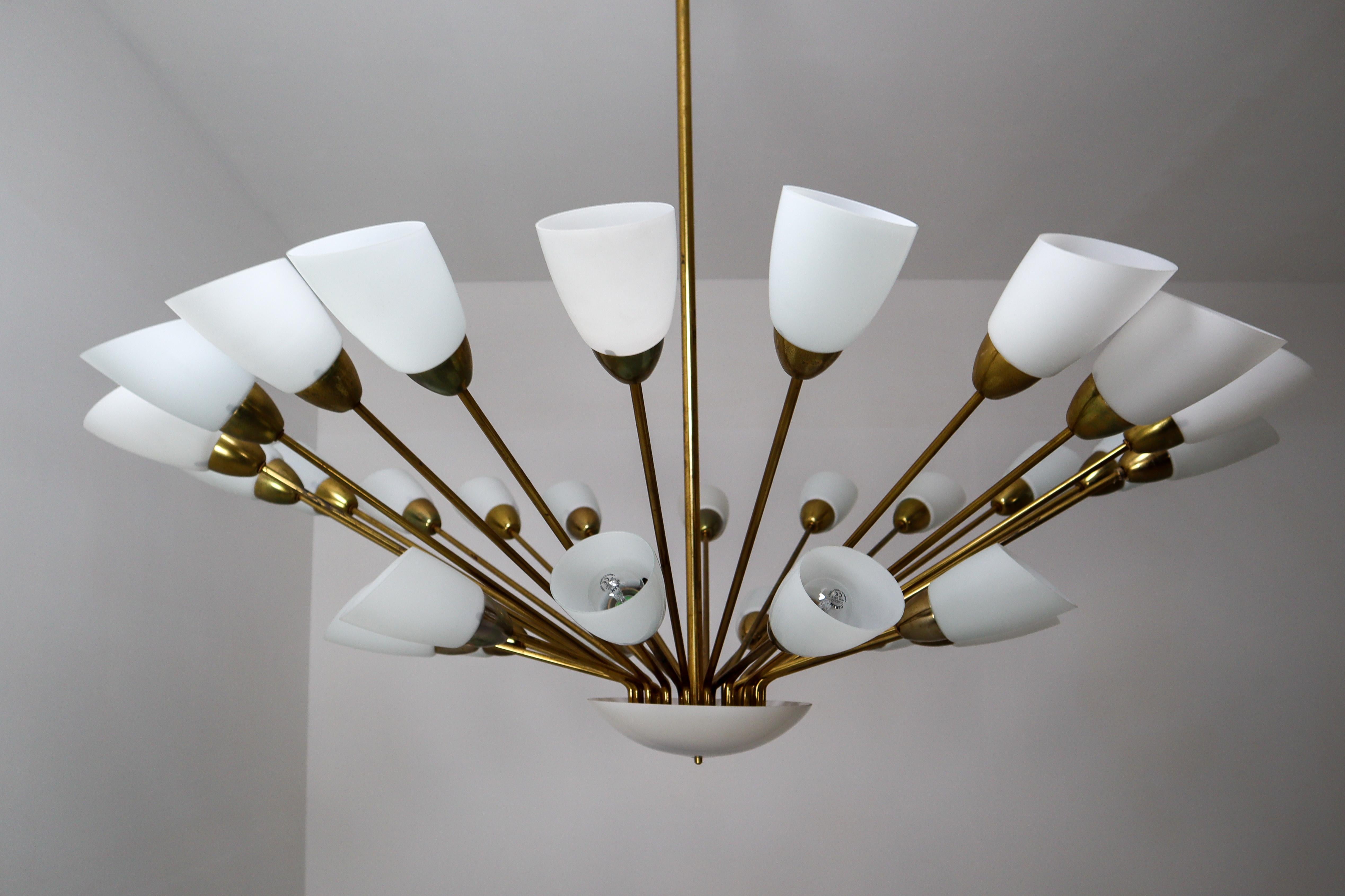 Ce Sputnik unique, de style moderne du milieu du siècle dernier, présente un design sculptural en forme d'araignée sur un cadre en laiton avec 30 douilles (E27) et contient 30 abat-jour en verre opalin blanc. Fabriqué en Autriche, fabriqué, vers les