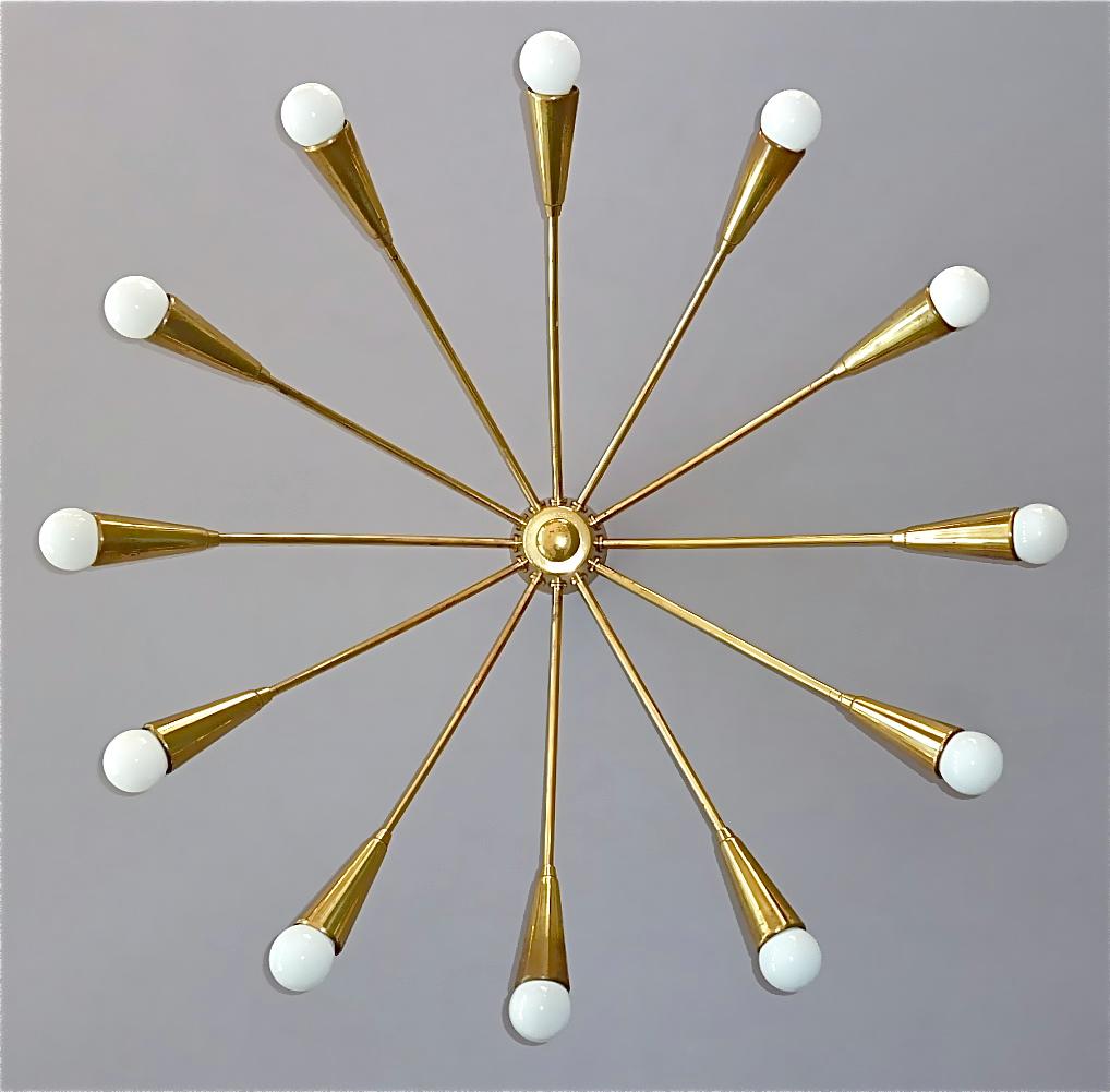 Large midcentury 12-light Sputnik flush mount or ceiling chandelier, Kaiser, Kalmar or Stilnovo style, Germany, circa 1950s. The stylish patinated brass ceiling lamp which is made of high quality has twelve elegant arms for twelve E14 standard screw