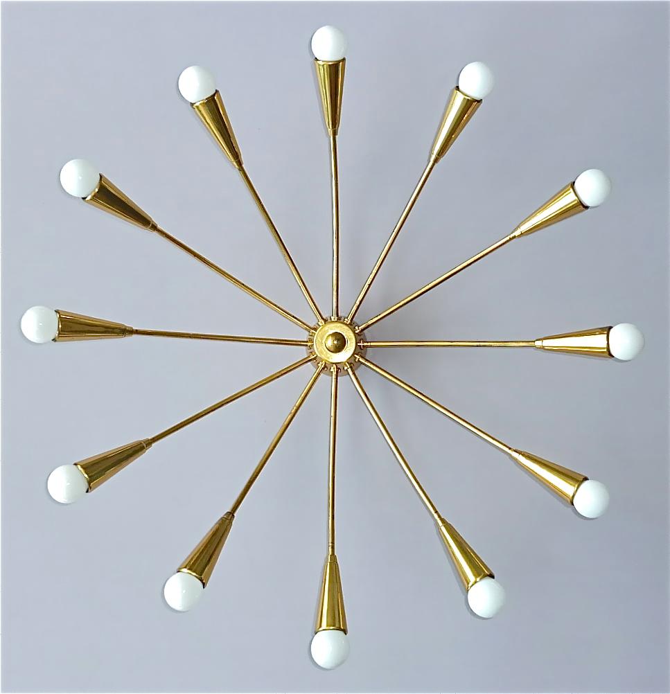 Large midcentury 12-light Sputnik flush mount or ceiling chandelier, Kaiser, Kalmar or Stilnovo style, Germany, circa 1950s. The stylish patinated brass ceiling lamp which is made of high quality has twelve elegant arms for twelve E14 standard screw