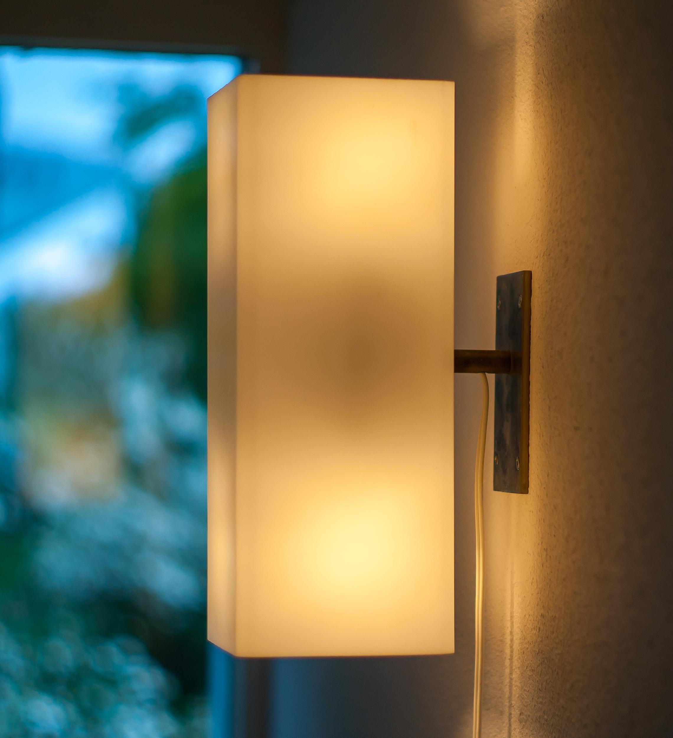 Large, well made architectural wall lamp with a nickel-plated steel frame and white Lucite shade.
Two light bulbs inside the lucite shade create an uplight and a downlight.
The lamp came from a modernist home in Holland where it had been in use