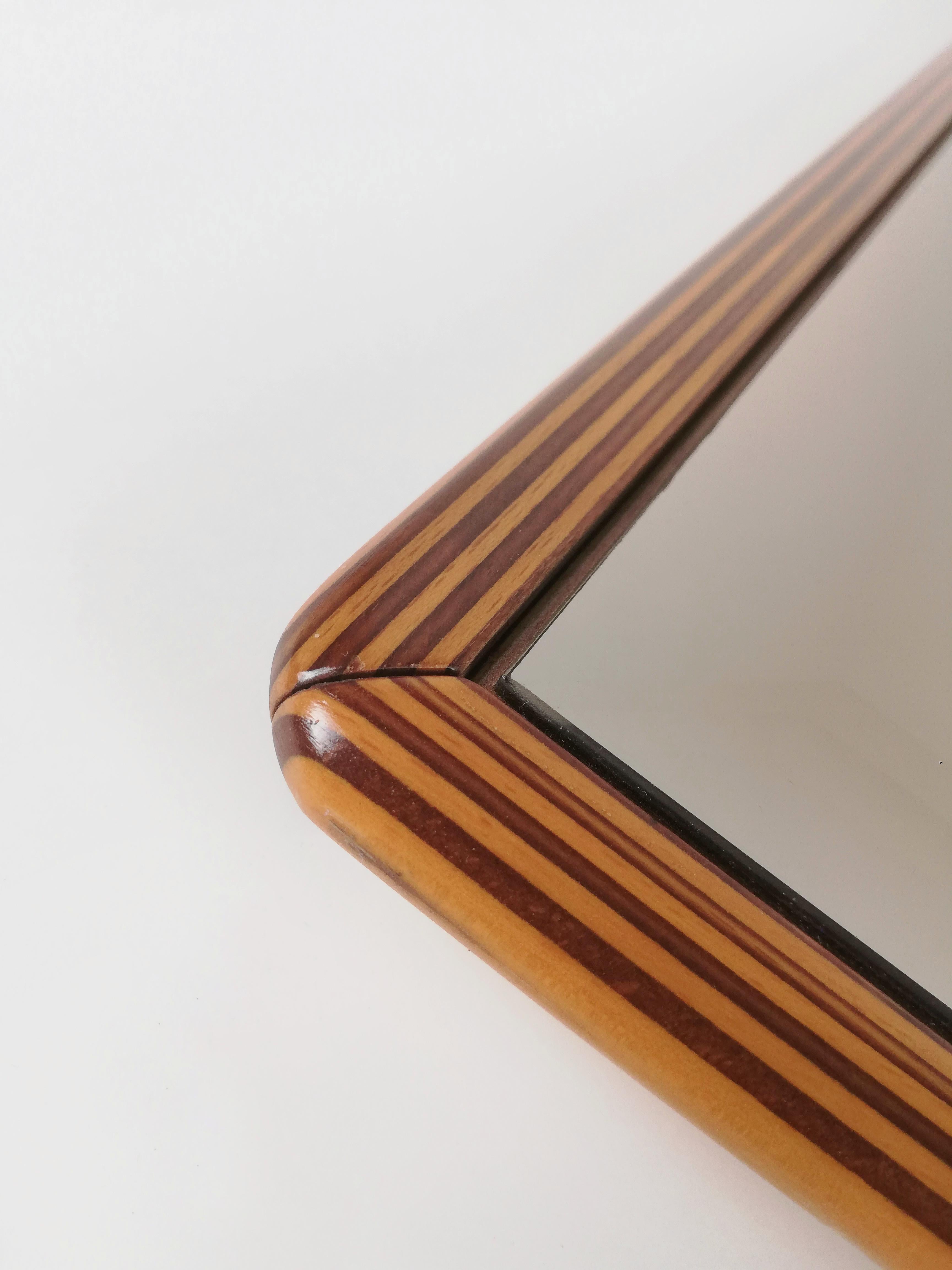 A mirror of high quality and precious workmanship.
It was made in Italy in the late 70s.
The two-tone solid walnut wood frame recalls the Artona collection produced by max Alto and designed by Afra and Tobia Scarpa.
The mirror is smoked and has a