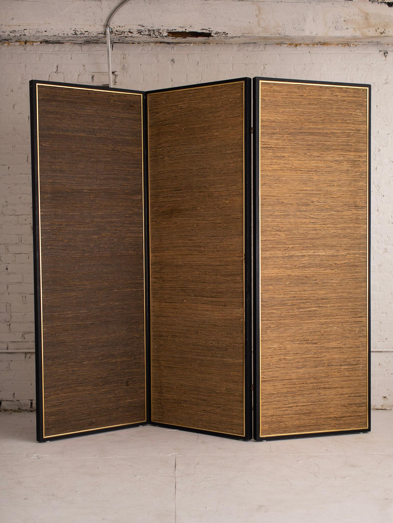 Extra large three panel folding screen / room divider. One side features smokey pale copper colored mirrors while the back side features grass cloth. Black edges with gold detail. Each panel separates for transport. Can be folded accordion style or