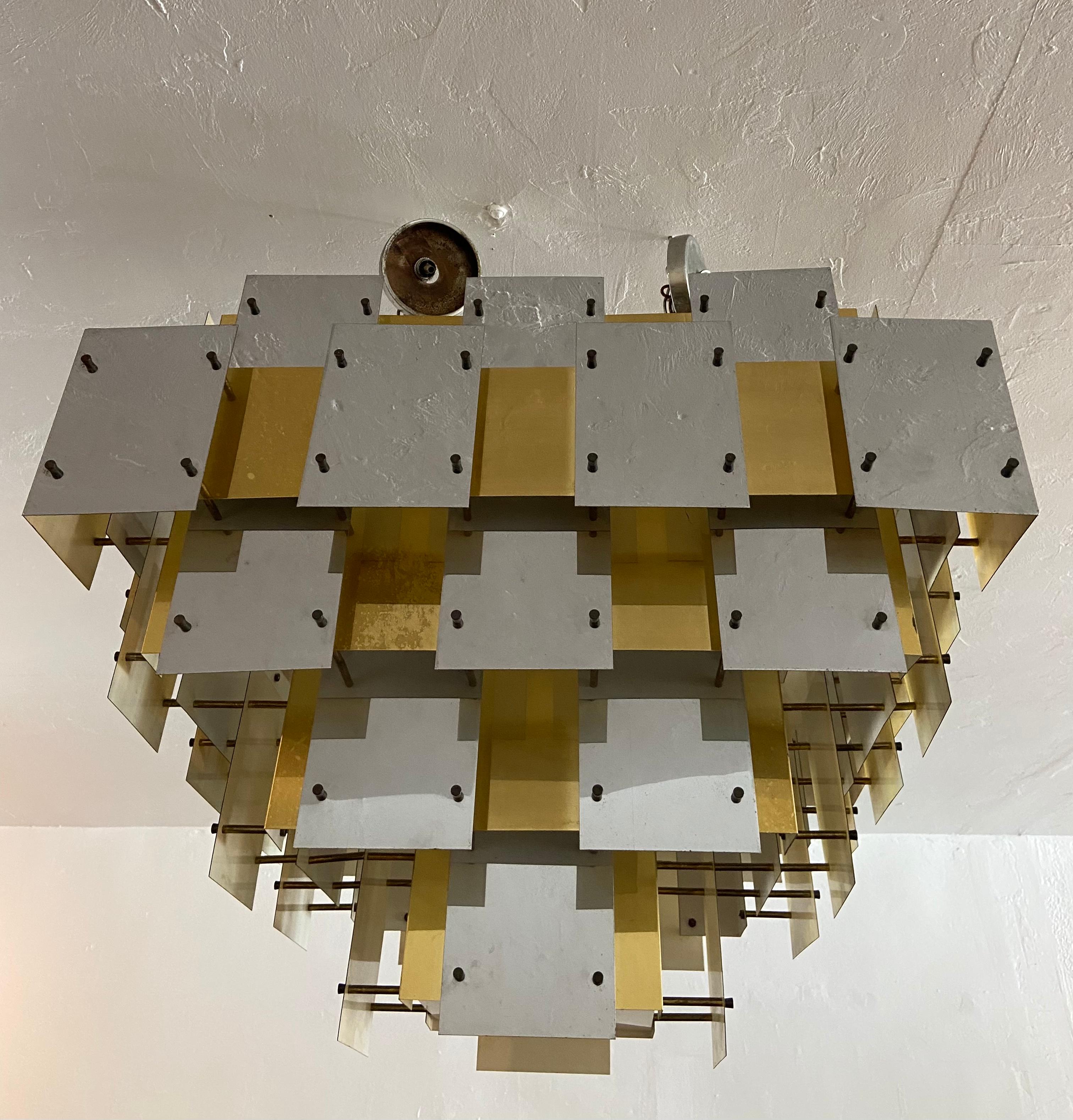 Large scale mixed metal cityscape chandelier by Robert Sonneman. Rare example consisting of alternating brass and polished aluminum plates bound by brass rods and screw in ends. 3 bulb system. Patina to the metal plates consistent with age and
