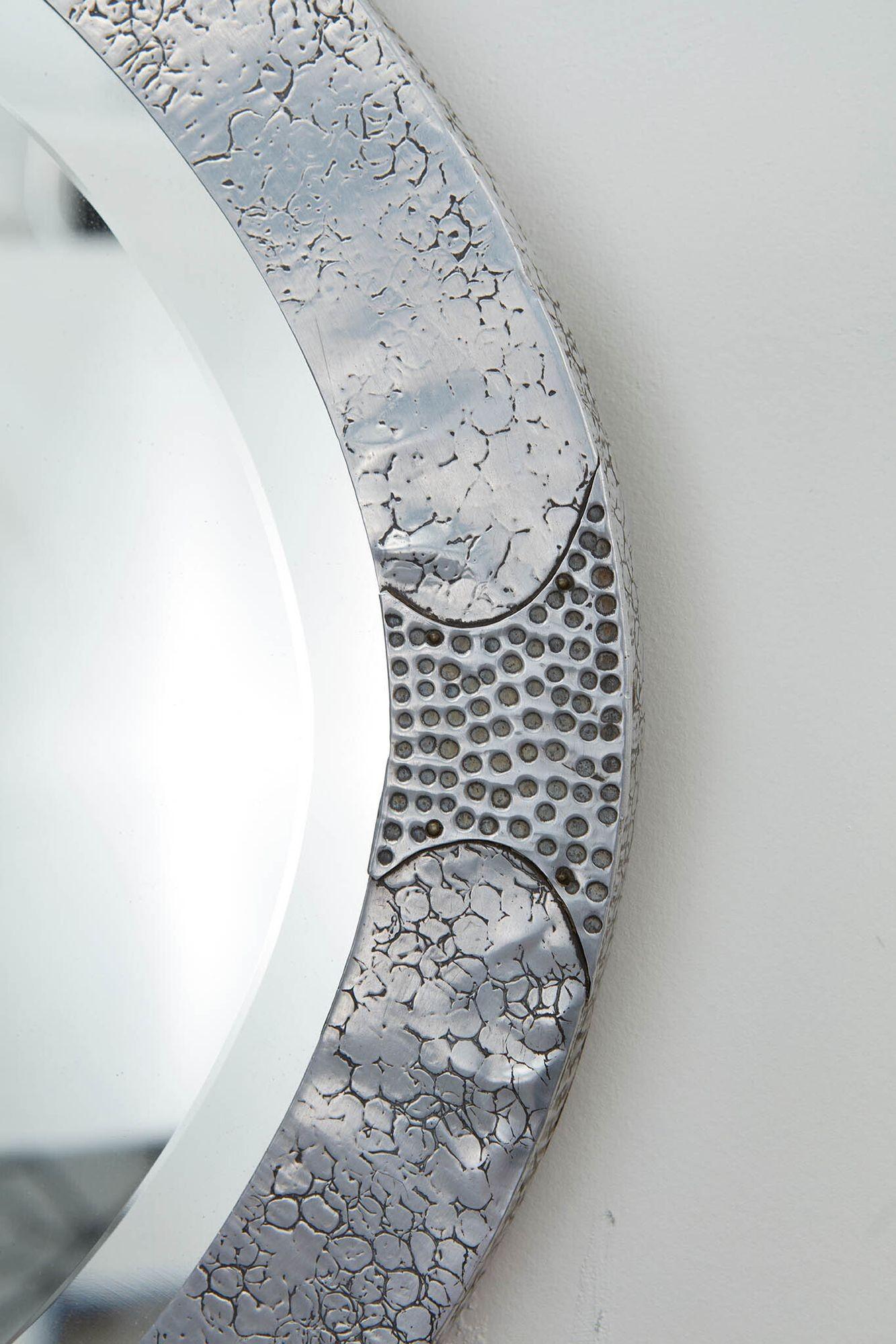 Ein ovaler Spiegel im Arts & Crafts-Stil aus handgehämmertem und gepunztem, poliertem Zinn, mit zwei Kupfercabochons und originalem, abgeschrägtem Glas und Rückwand. Guter Maßstab und auffälliges Finish.
