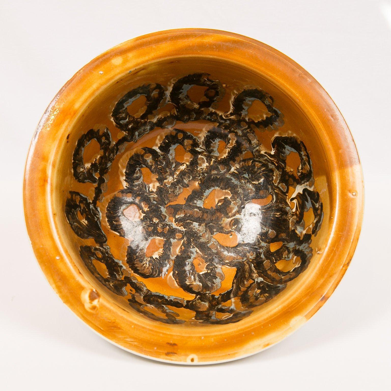 An exceptionally large and rare mid-19th century English mocha ware bowl with an everted lip. Decorated on the inside with a remarkable three color cable of dark brown, light brown and light blue which covers most of the well. The slip decoration