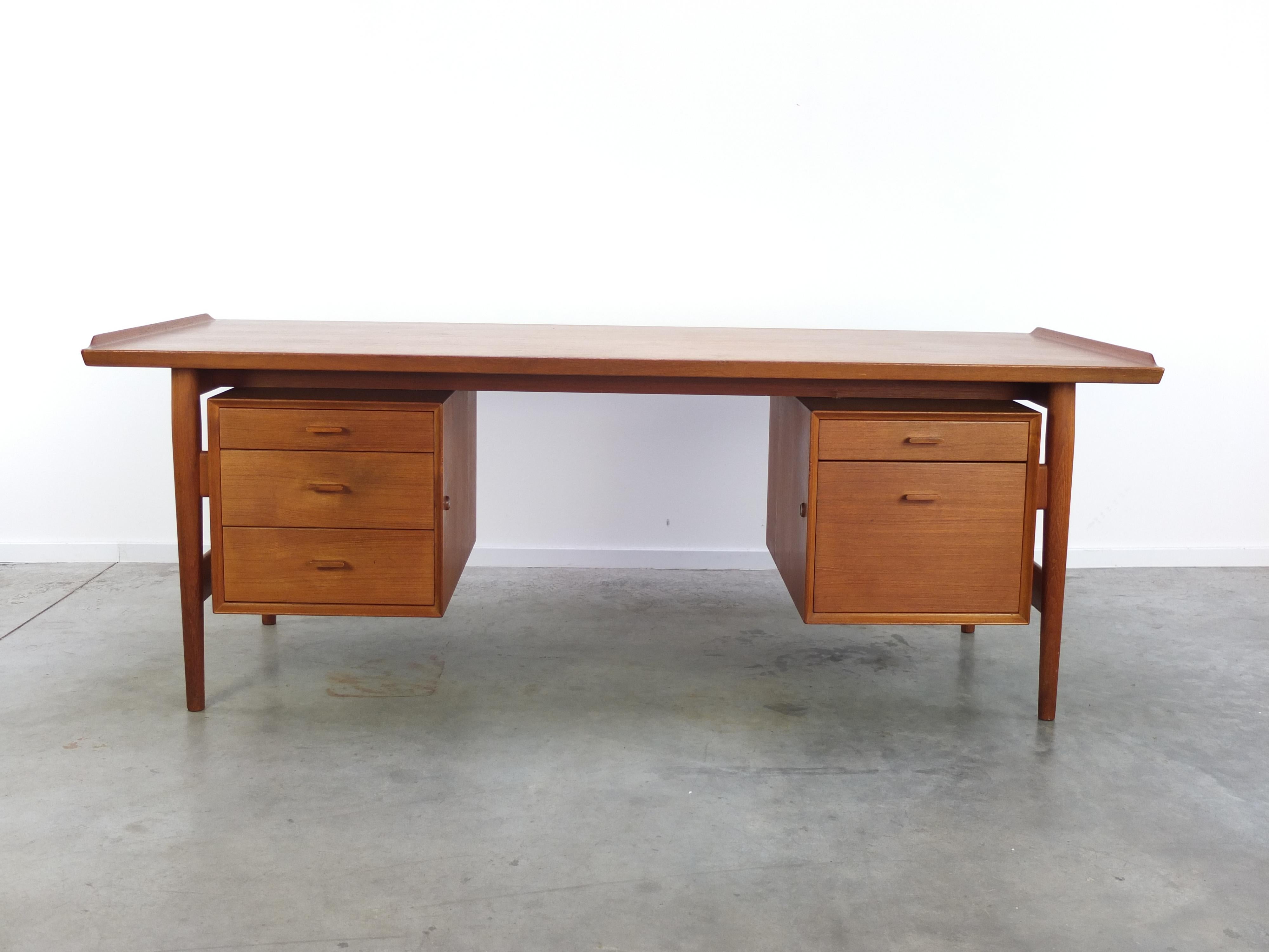 Large executive desk designed by Arne Vodder in the 1950s. This is ‘Model 207’ made of teak wood. There are two drawers compartments and a great is detail is the raised edge on both sides of the top. The backside of this desk is fully finished so it