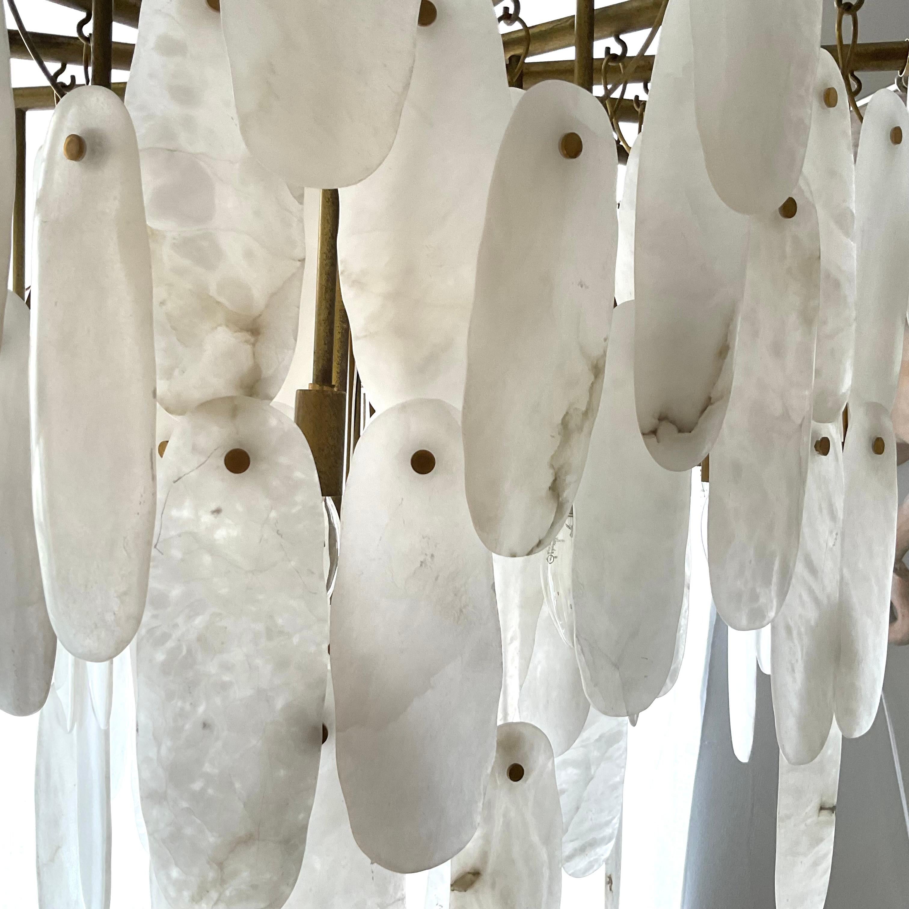 A stunning mid-century Italian Chandelier composed of cascading natural Capiz shells suspended from a tiered brass frame. Each hand-cut shell piece delicately hung to form a soft, sculptural silhouette that shimmers beautifully when illuminated.