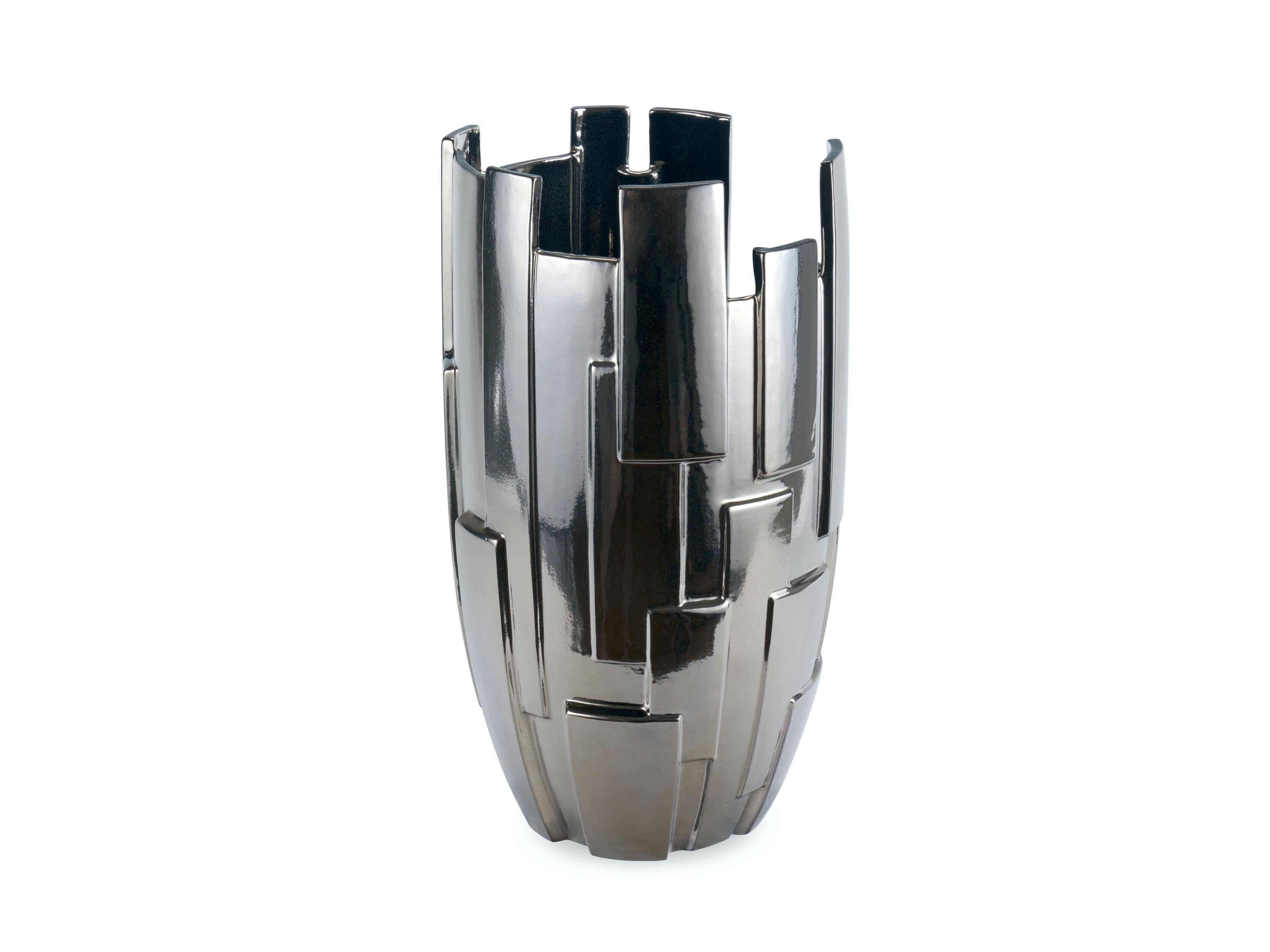 Il vaso scultoreo 'Panoplia Titanium' si distingue per la sua particolare forma caratterizzata da un'alternanza di vuoti e pieni sovrapposti che lo rendono un vaso dai 'mille volti': guardandolo da ogni angolazione, quest'opera d'arte appare