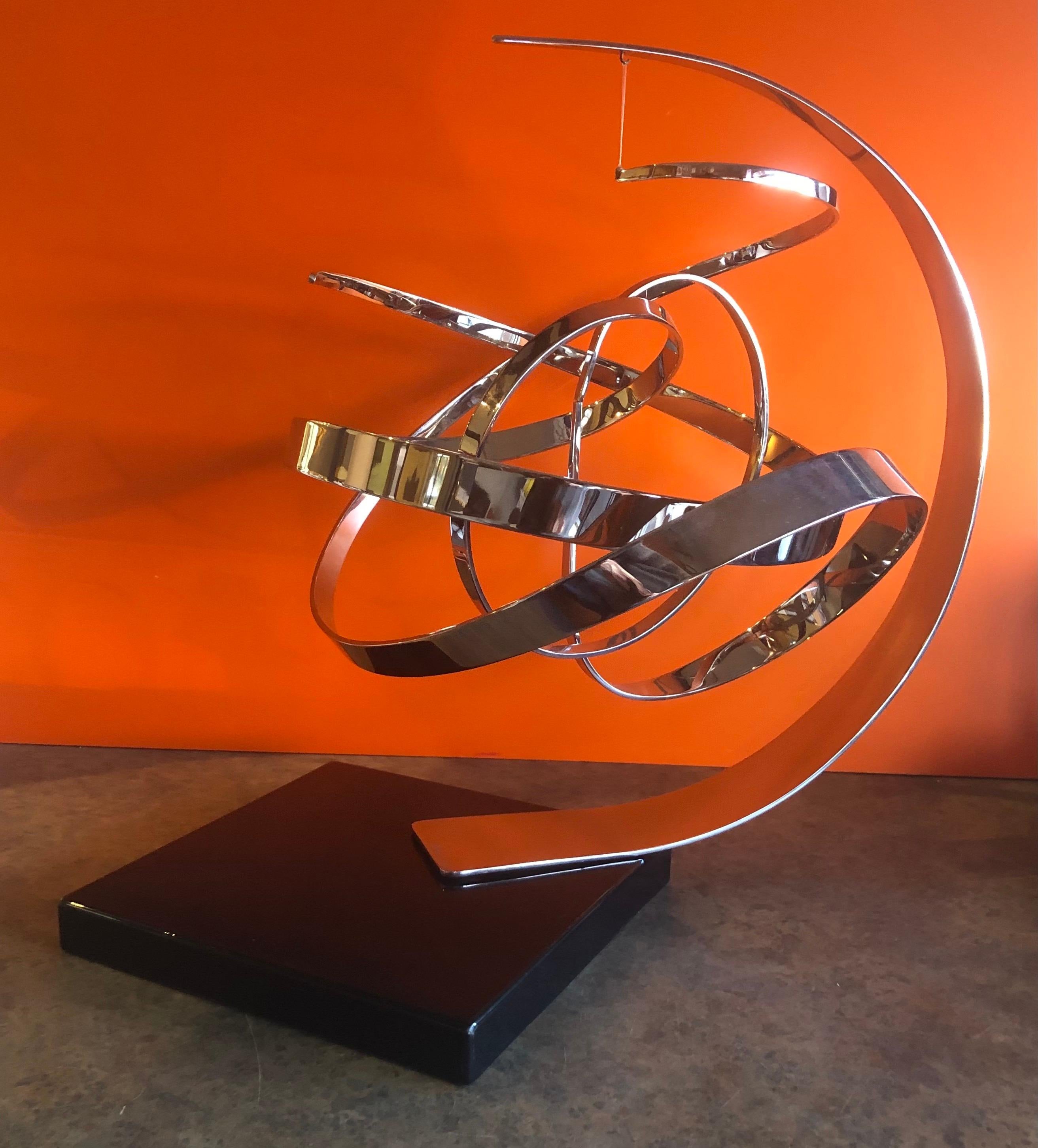 Stunning large modern chrome on black marble base kinetic sculpture by noted artist Michael Cutler, circa 1982.

Dimensions: 19